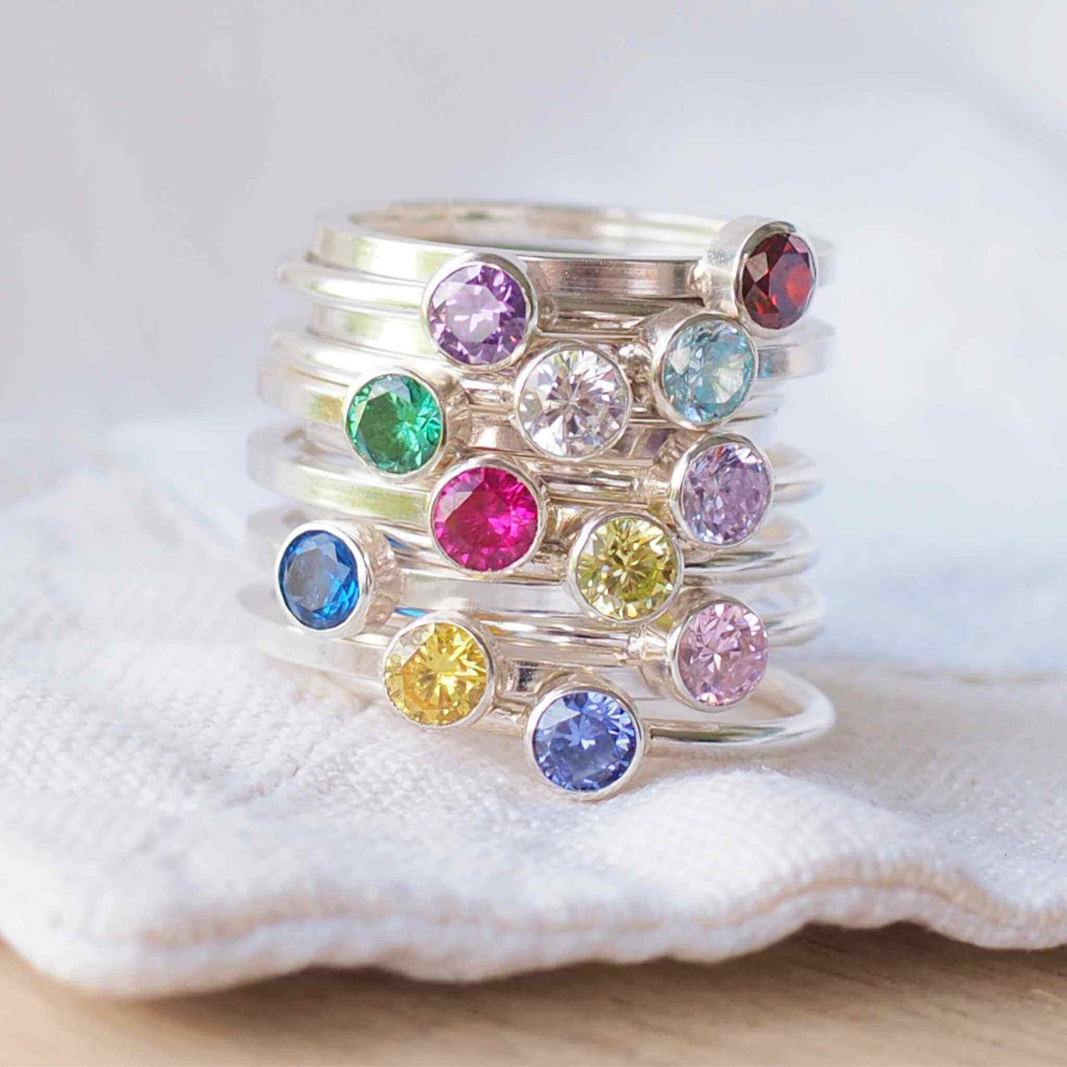 Stack of birthstone rings in Sterling Silver with a round coloured cubic zirconia in 4mm size to mark birthstones for every month. Handmade in Scotland by maram jewellery