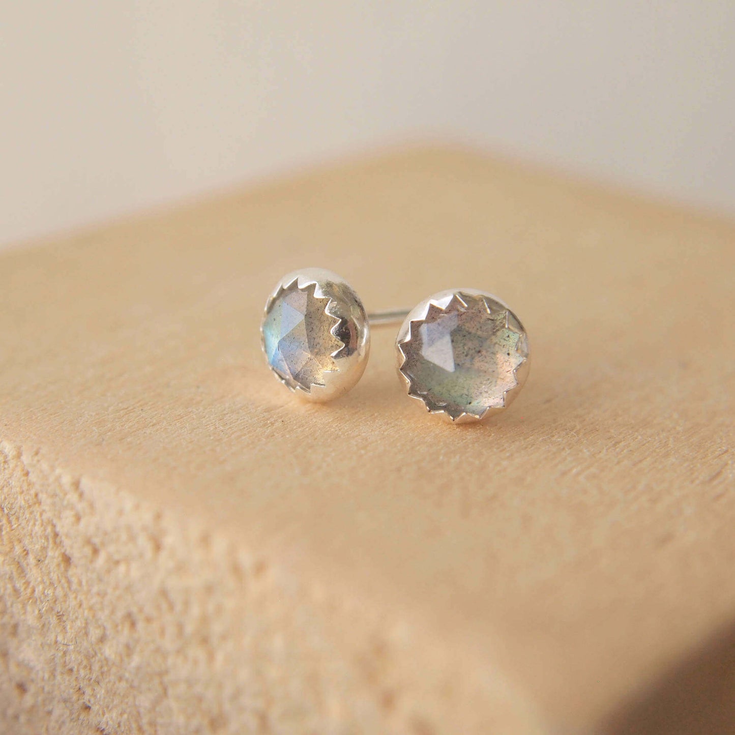 Labradorite and sterling silver simple gemstone earrings made by maram jewellery, a small indie jeweller in Scotland UK. Made from Sterling Silver, the colour changing labradorite is set in a simple modern setting with a wavy serrated edge. The earrings measure 5mm in size