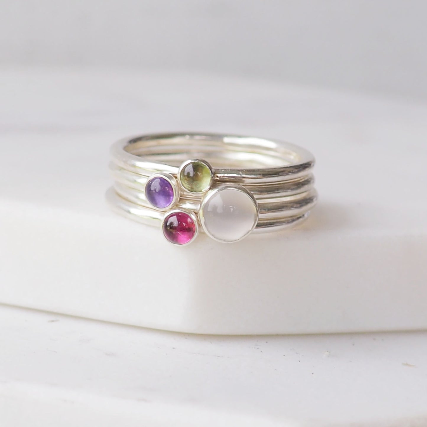 gemstone Birthstone rings in silver, moonstone, amethyst, Garnet and peridot to symbolise June, February, August and January Birthstones. Handmade in Scotland UK by Maram Jewellery