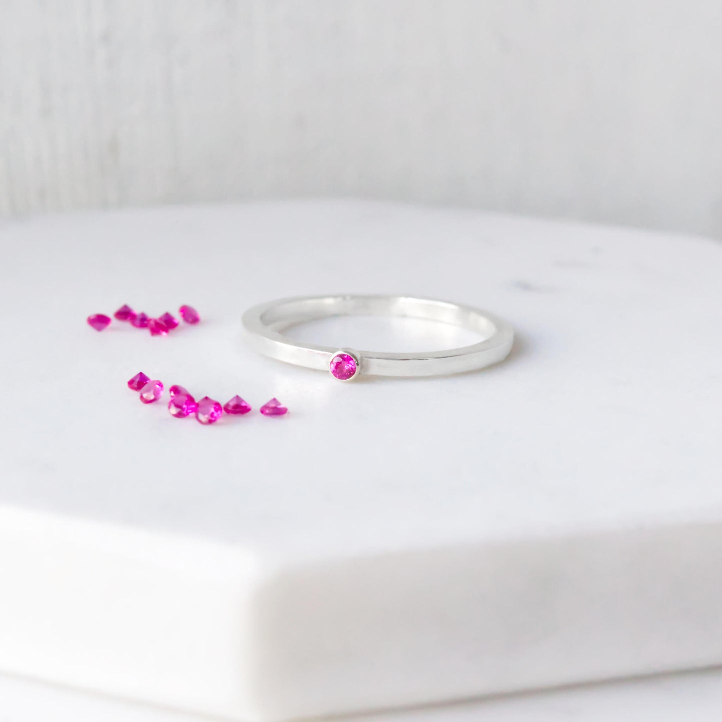 Silver pink gemstone ring with ruby cubic zirconia and sterling silver. A square silver band ring with a small round 2mm facet round solitaire. Jult birthstone Jewellery handmade in Scotland UK