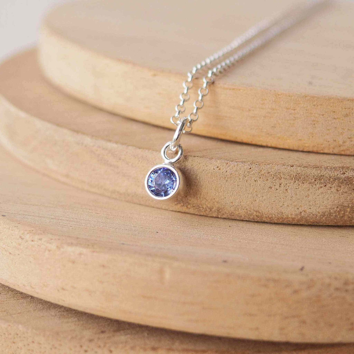 Small Sterling Silver and Cubic Zirconia Sapphire Blue necklace. A small 4mm facet round blue gemstone with a simple silver setting on a trace style chain, suitable as a September Birthstone charm . Handmade in Scotland by Maram Jewellery