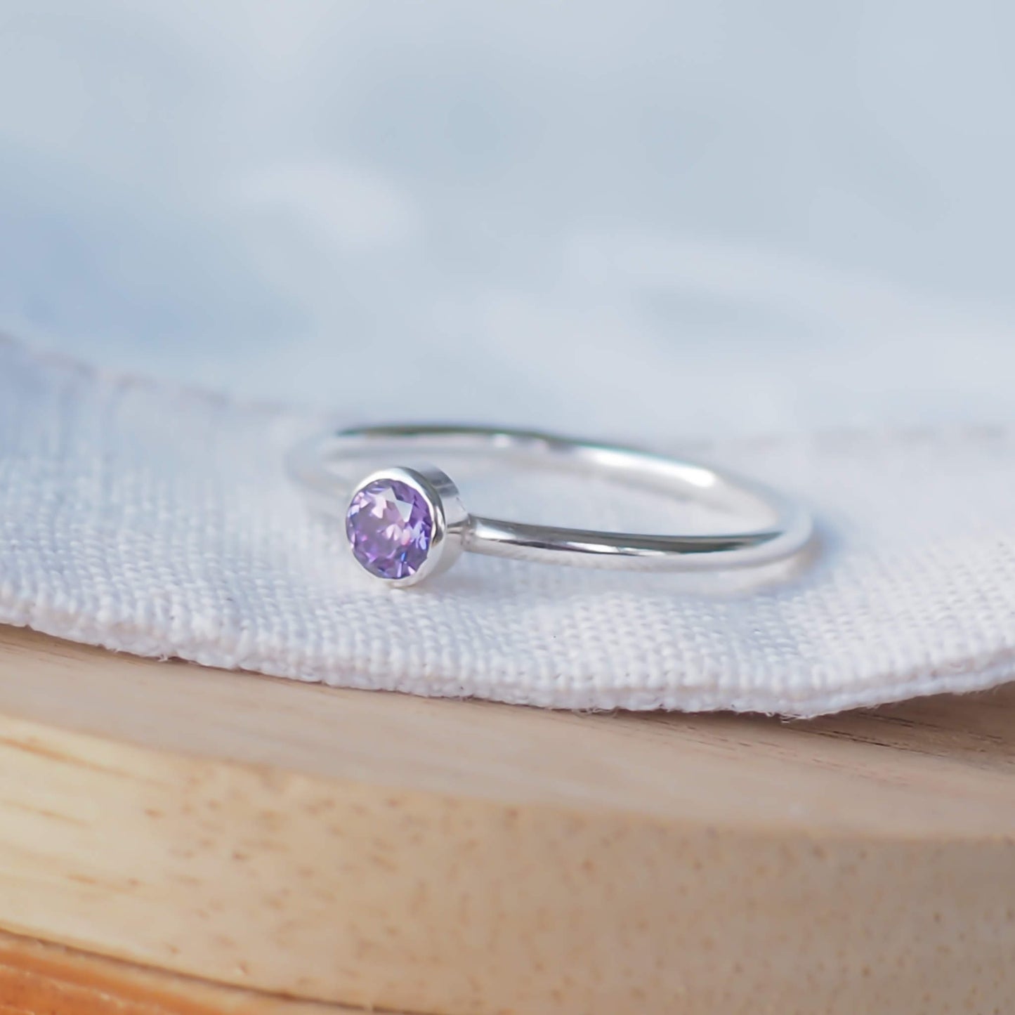 Purple Gemstone ring in Sterling Silver with a round amethyst 4mm birthstone set simply onto a modern fully round band of sterling silver. Handmade in Scotland by maram jewellery