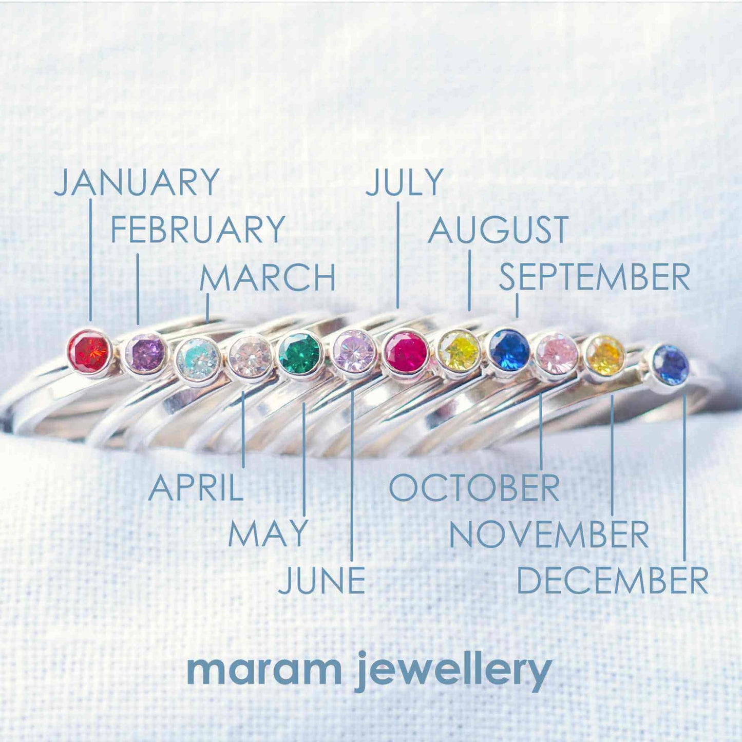 Infographic to show birthstone colours for maram jewellery's range of cubic zirconia rings. the rings are simple styled with plain bands and 3mm round facet cut gemstones in bright colours. Handmade in Scotland by a small business jewellery