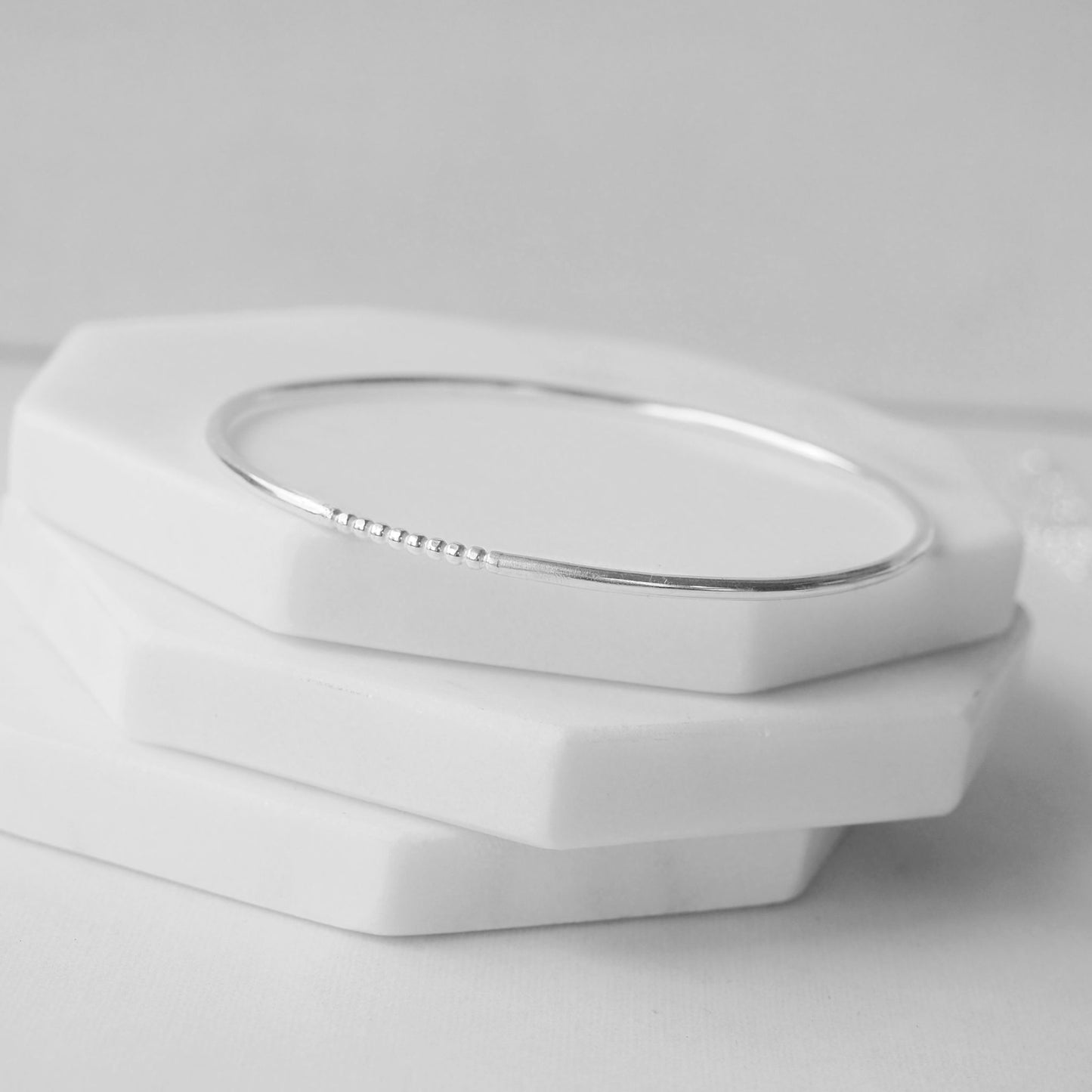 Silver bangle made by maram jewellery in Scotland UK. Made in a round halo profile with a fixed beaded section. THese bangles are made with leftover sections on silver so are eco friendly. Made in Scotland UK