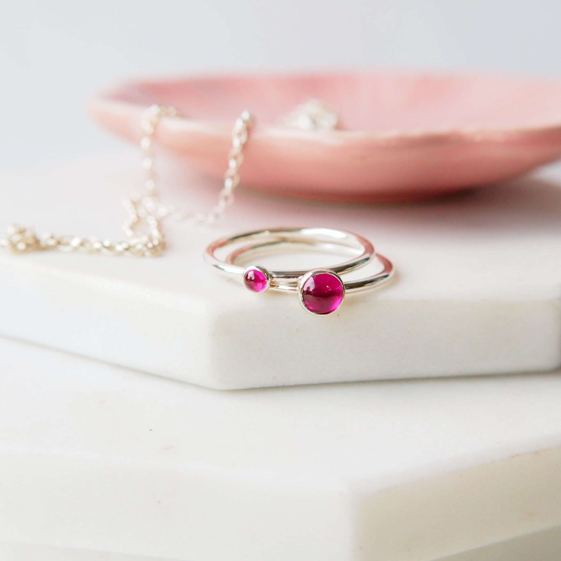 Silver ring with a pink gemstone on a white surface. Handmade by maram jewellery in Scotland