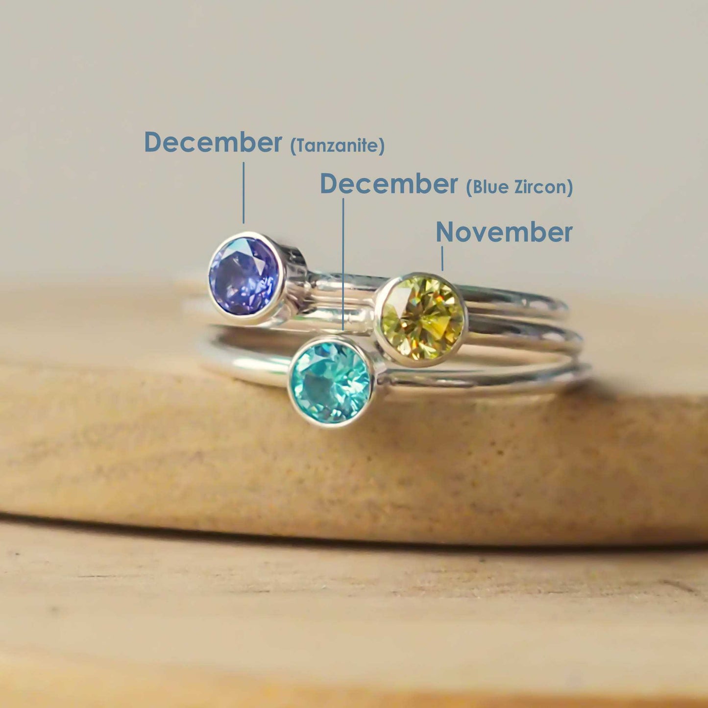Three rings showing December gem variations - Tanzanite and Blue Zircon, as well as a Citrine for November. These are sterling silver stacking rings made in Scotland by maram jewellery