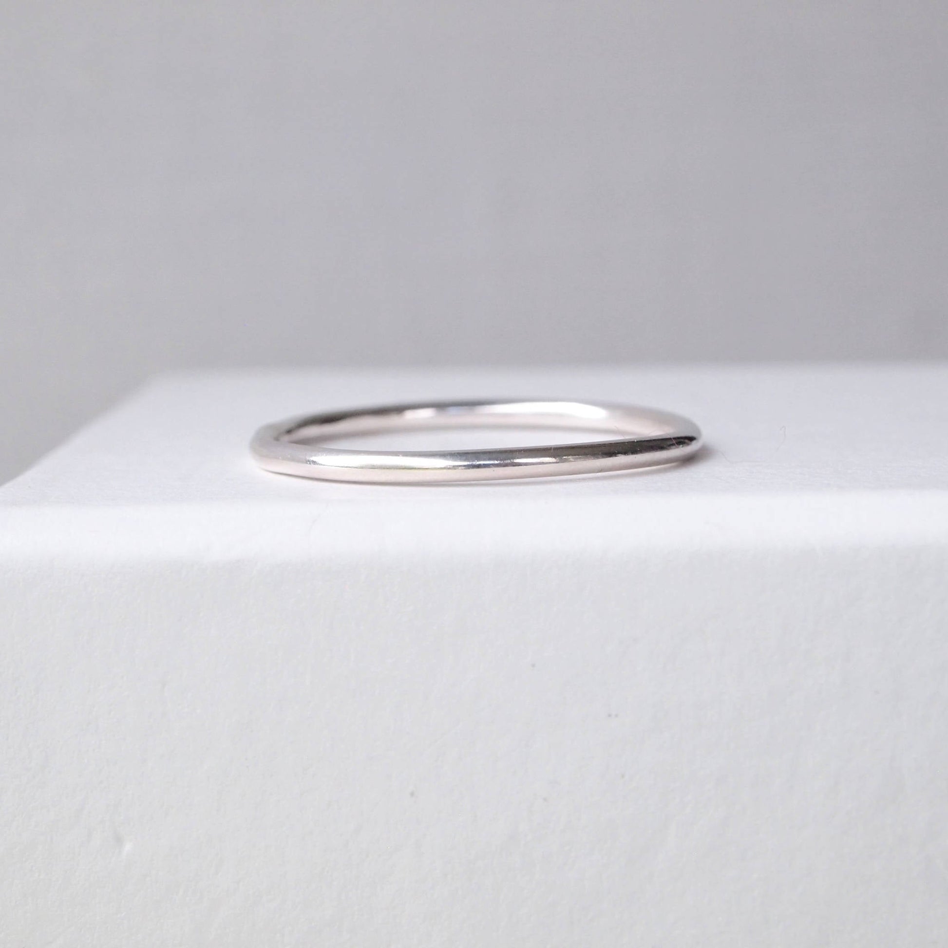 Plain round profile wedding plain band with no details. minimalist sterling Silver ring pictured on a white background. Handmade to your ring size by maram jewellery in Edinburgh UK