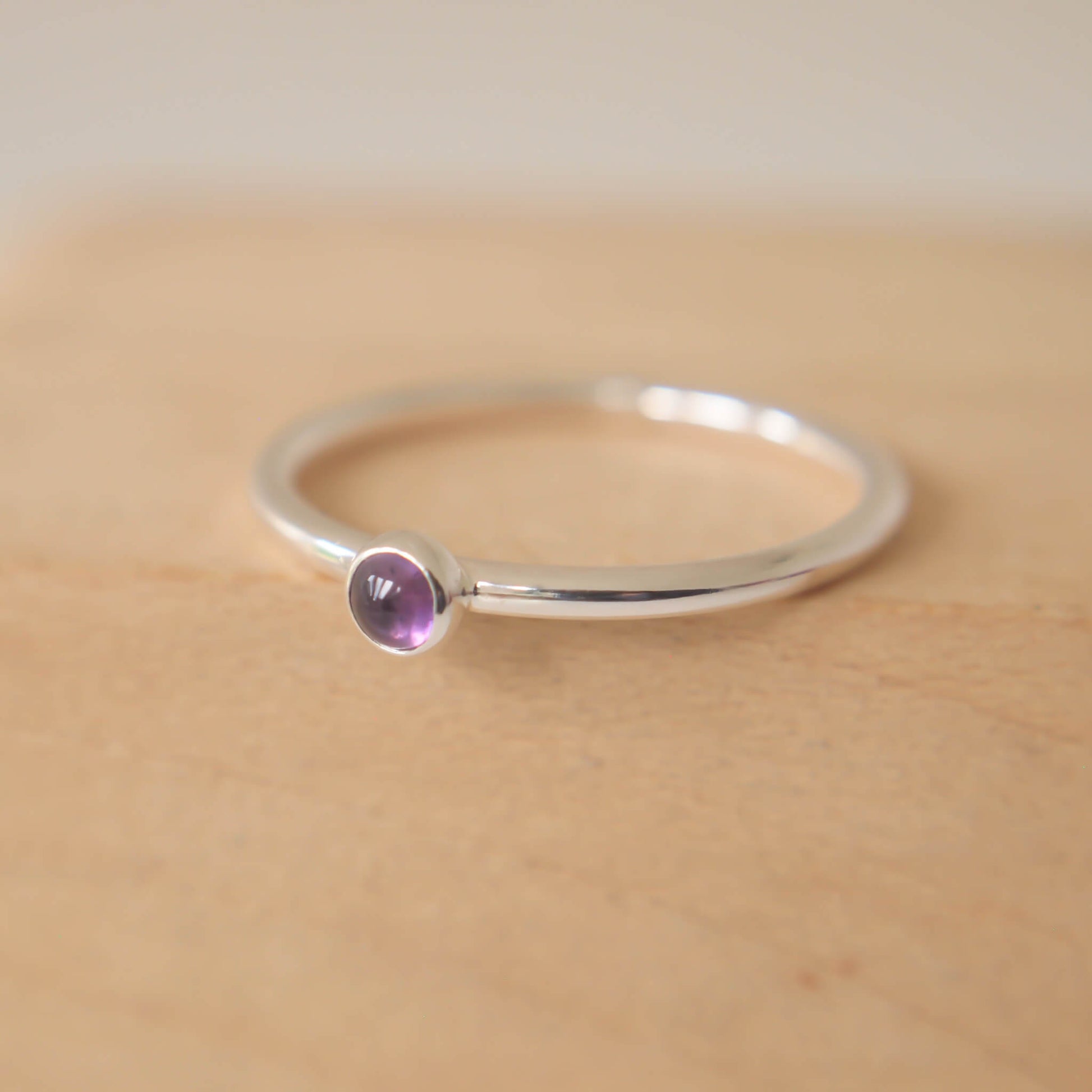 Amethyst and Sterling Silver Ring made from a small 3mm round deep purple Amethyst gemstone set simply onto a modern band of fully round wire. Handmade to your ring size by maram jewellery in Scotland