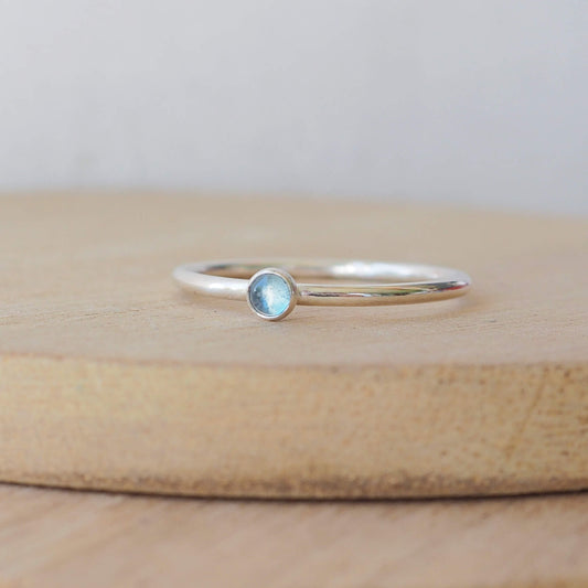 Small gemstone ring in sterling silver with a modern round band with a 3mm sized round light blue Aquamarine. Handmade in Edinburgh by Maram Jewellery