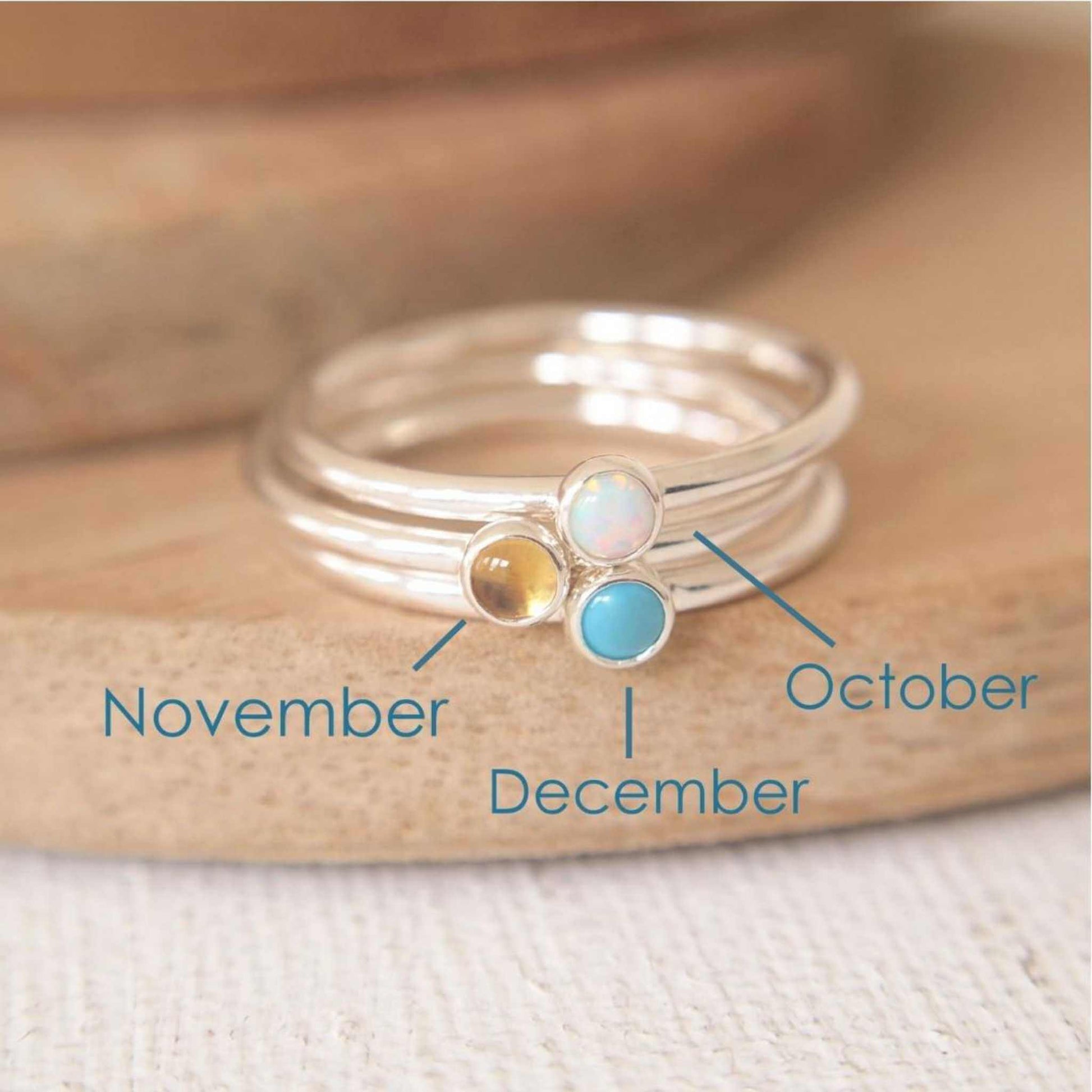 Three Silver rings, each set simply with a single gemstone in Lab Opal, Citrine and Turquoise in a round 3mm size. Birthstones for October, November and December. Handmade in Scotland by Maram Jewellery