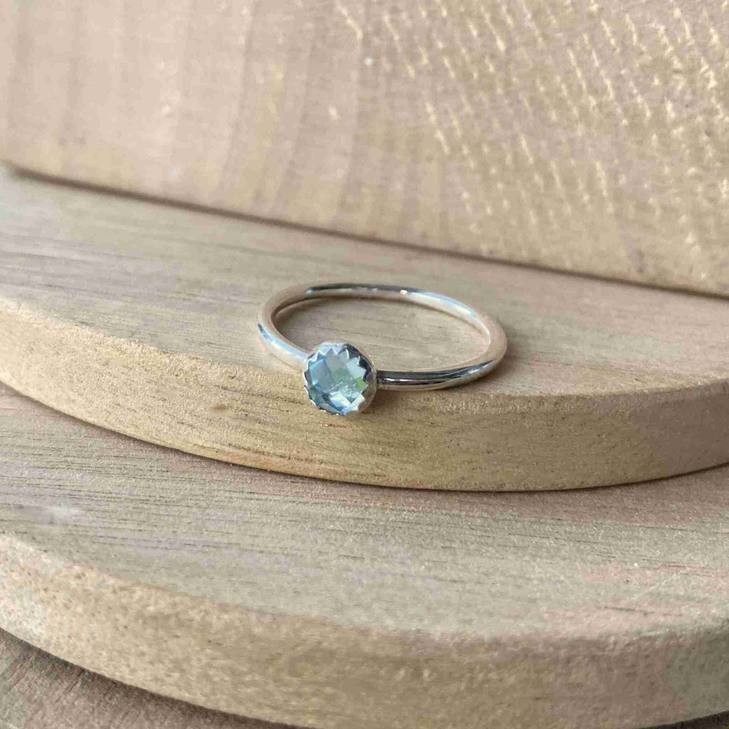 Blue Topaz and Sterling Silver Birthstone RIng for March. The ring is simple in style on a plain fully round band with a small round facet cut pale blue topaz in the centre. The ring is handmade to your size by maram jewellery in Scotland
