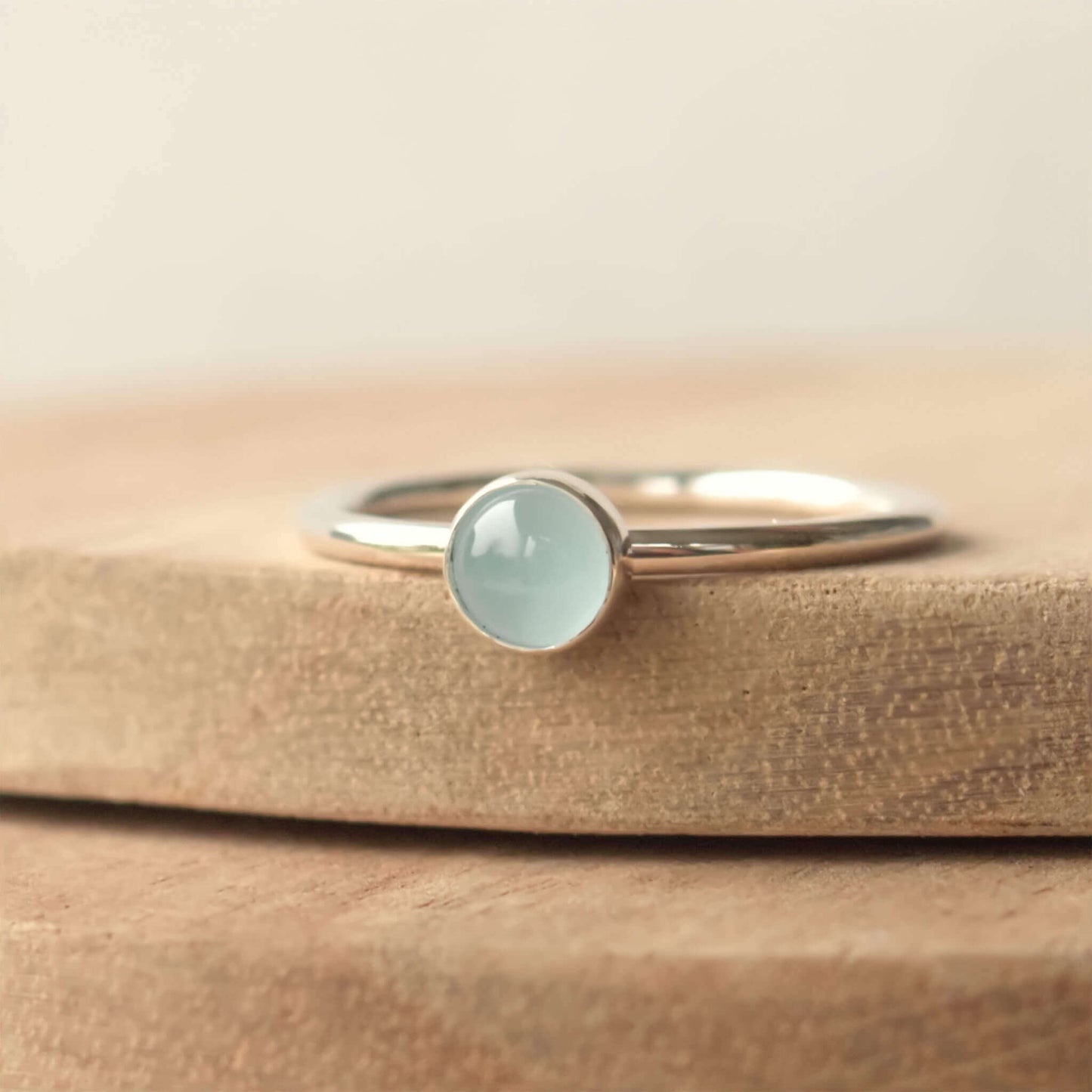 Cloudy Aquamarine birthstone ring for March. A 5mm round pale blue cabochon set simply onto a simple round band. The ring is made to measure to your size by maram jewellery in Scotland