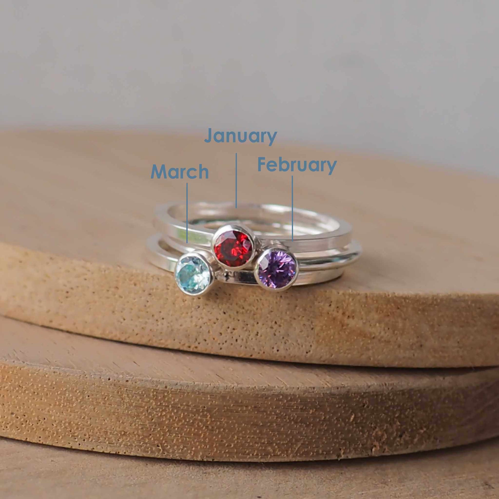 Three silver and gemstone rings with January, February and March birthstones. Silver rings with a 4 mm size stone in simple style with a red, purple and aqua gemstone. Handmade in Scotland by Maram Jewellery