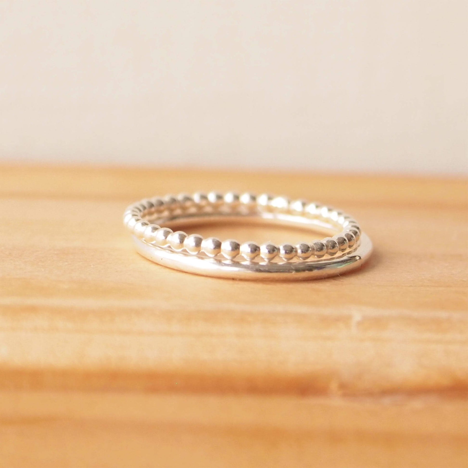 Double silver ring set with two textured band. One is a fully round halo style band and the second is a 'bubble' style ring that is made from tiny circles of sterling silver pearl wire in a row. The rings are Sterling Silver and Handmade in Scotland by maram jewellery