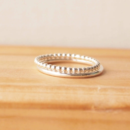 Double silver ring set with two textured band. One is a fully round halo style band and the second is a 'bubble' style ring that is made from tiny circles of sterling silver pearl wire in a row. The rings are Sterling Silver and Handmade in Scotland by maram jewellery