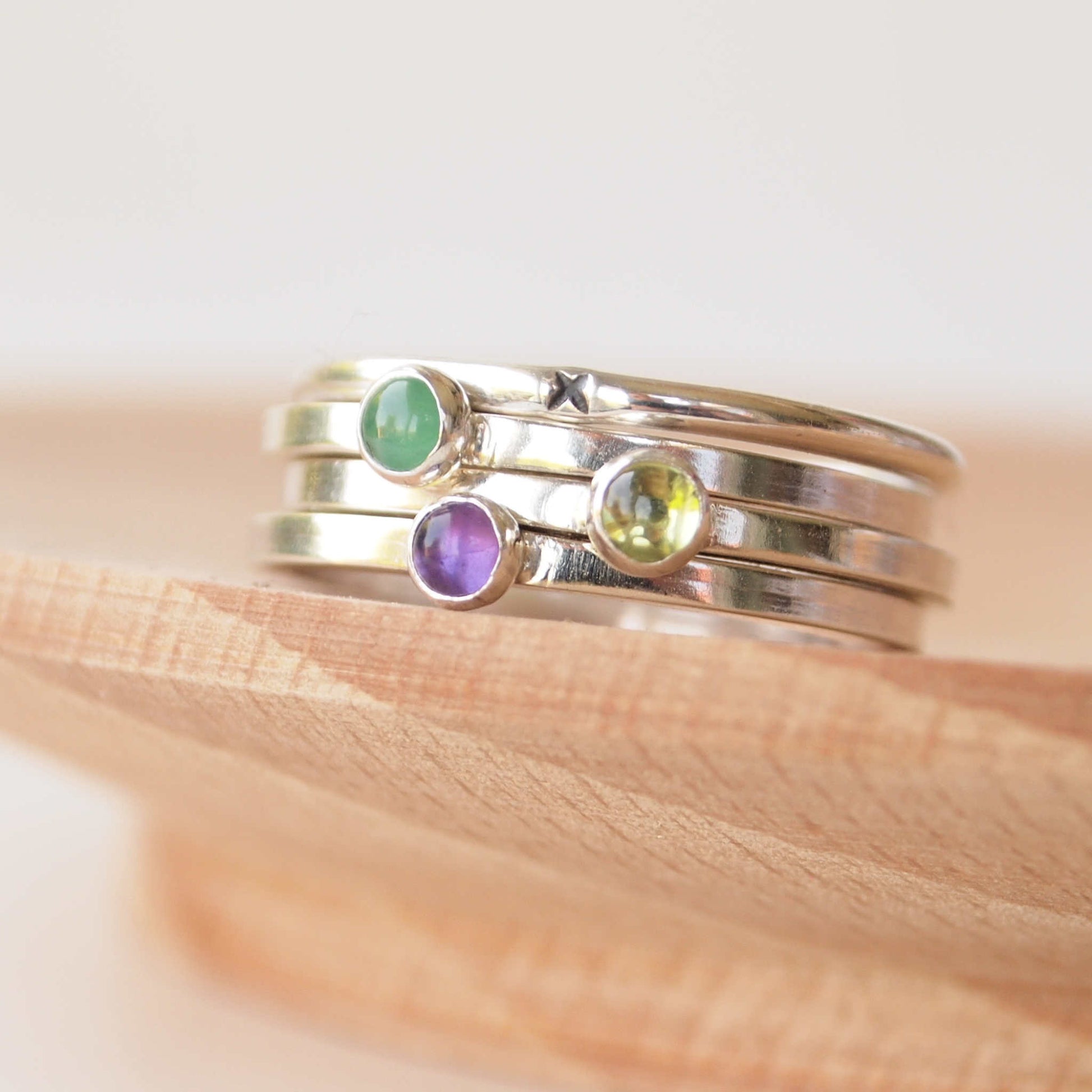 Group of Birthstone rings with May, February and August Birthstones. Features Green Emerald, Purple Amethyst and green Peridot, all in sterling silver and modern square bands. Handmade bot maram jewellery in Scotland