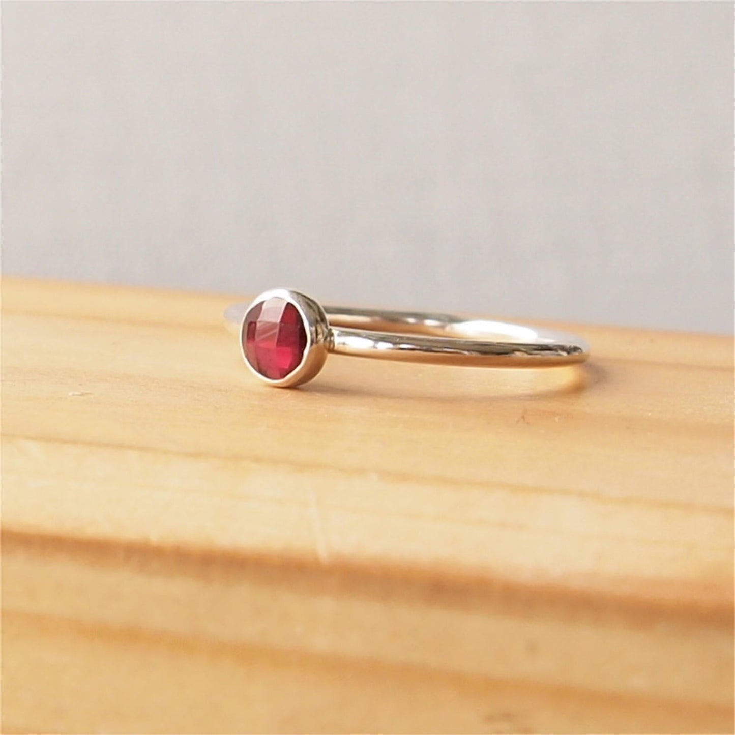 Simple Silver and Garnet ring with a 5mm round deep red cabochon set simply on a round band. Birthstone for January. Handmade by Maram Jewellery in Scotland