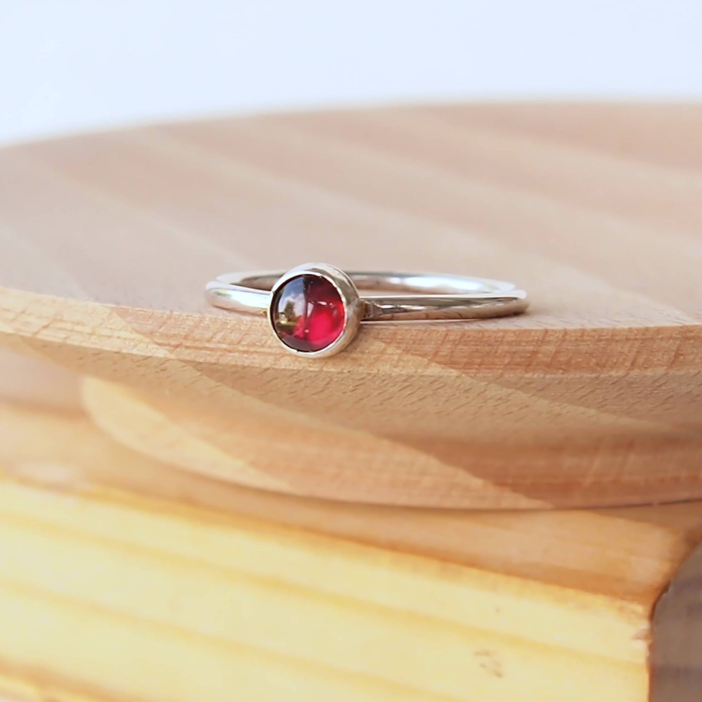 Simple Silver and Garnet ring with a 5mm round deep red cabochon set simply on a round band. Birthstone for January. Handmade by Maram Jewellery in Scotland