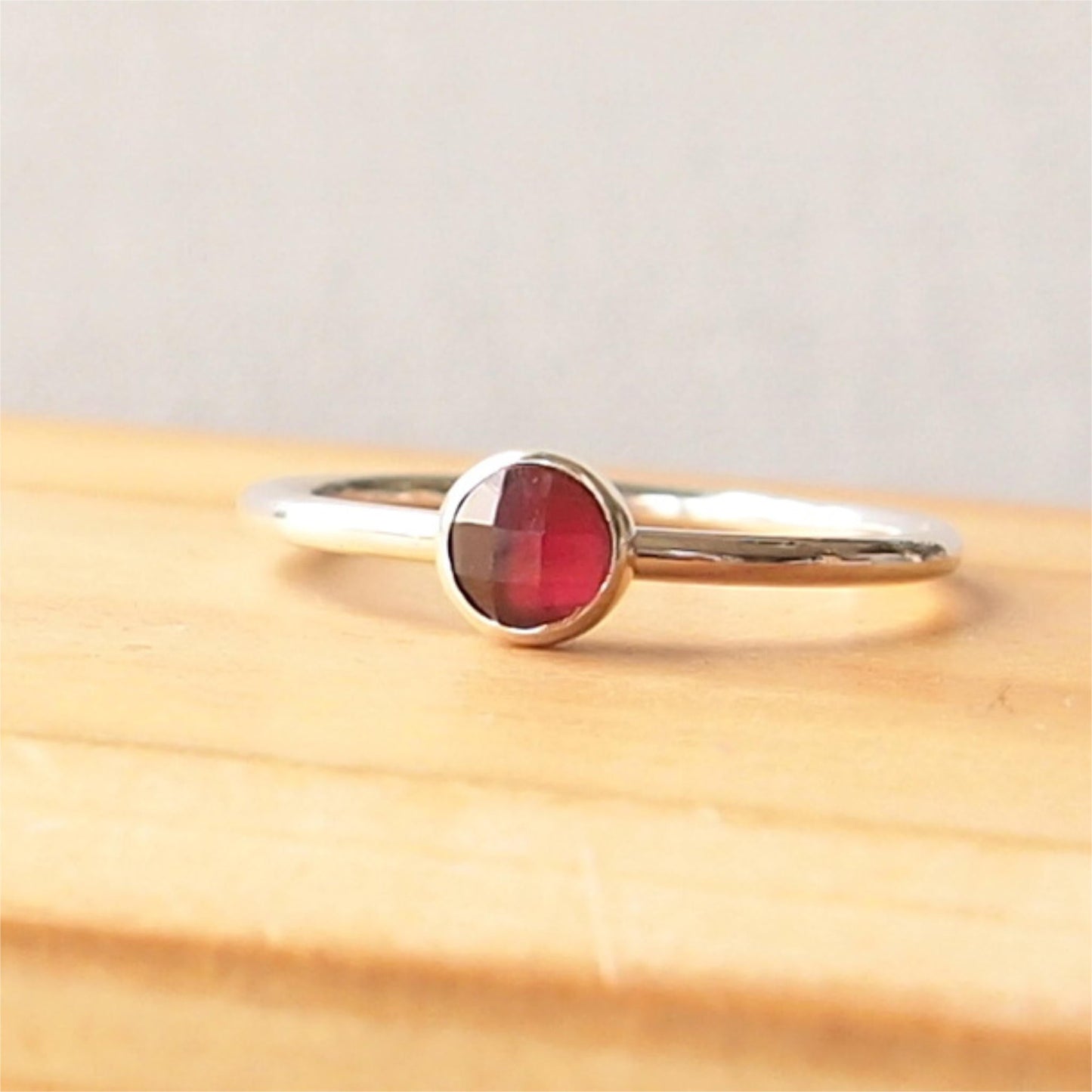 Simple Silver and Garnet ring with a 5mm round deep red cabochon set simply on a round band. Birthstone for January. Handmade by Maram Jewellery in Scotland