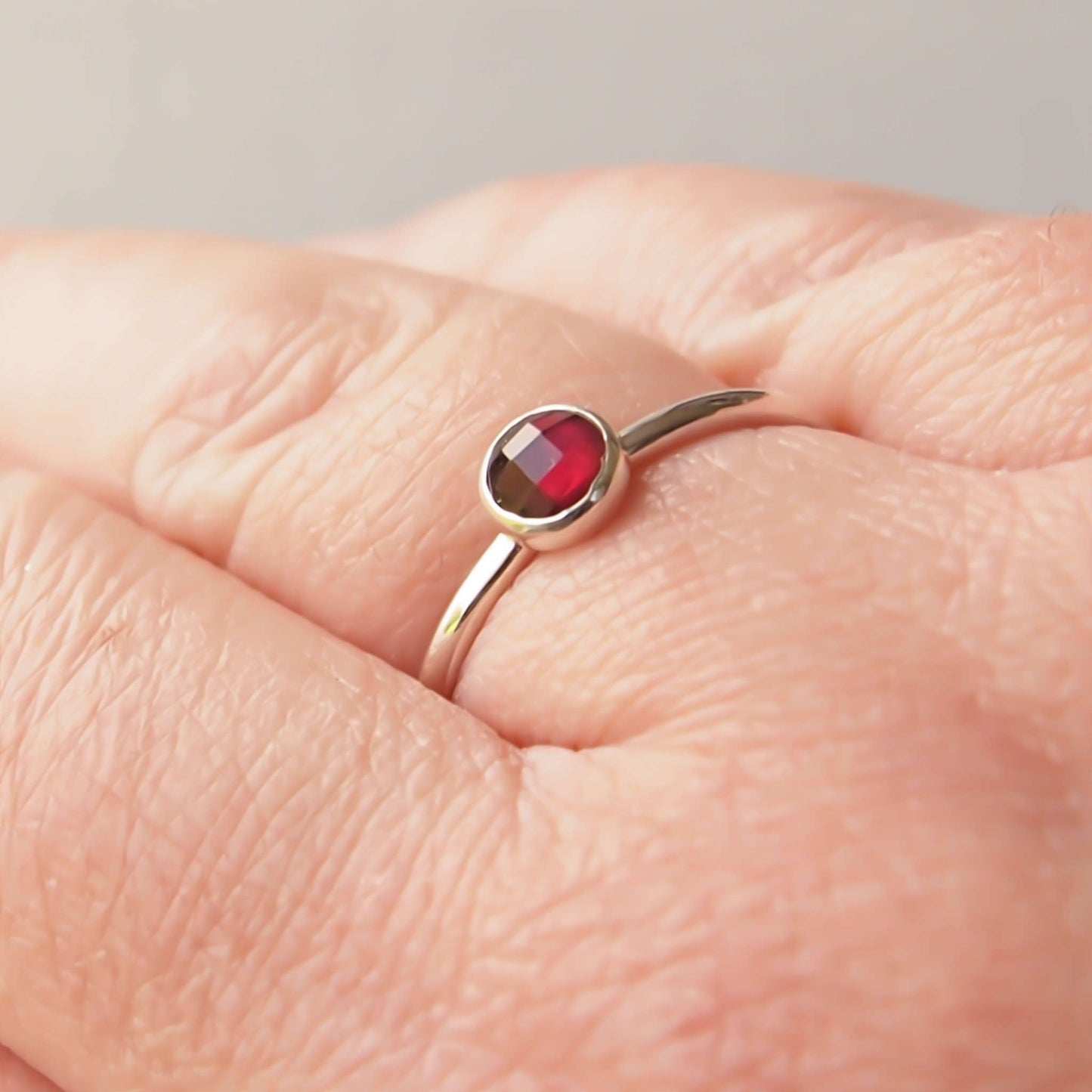 Simple Silver and Garnet ring with a 5mm round deep red cabochon set simply on a round band. Birthstone for January. Handmade by Maram Jewellery in Scotland