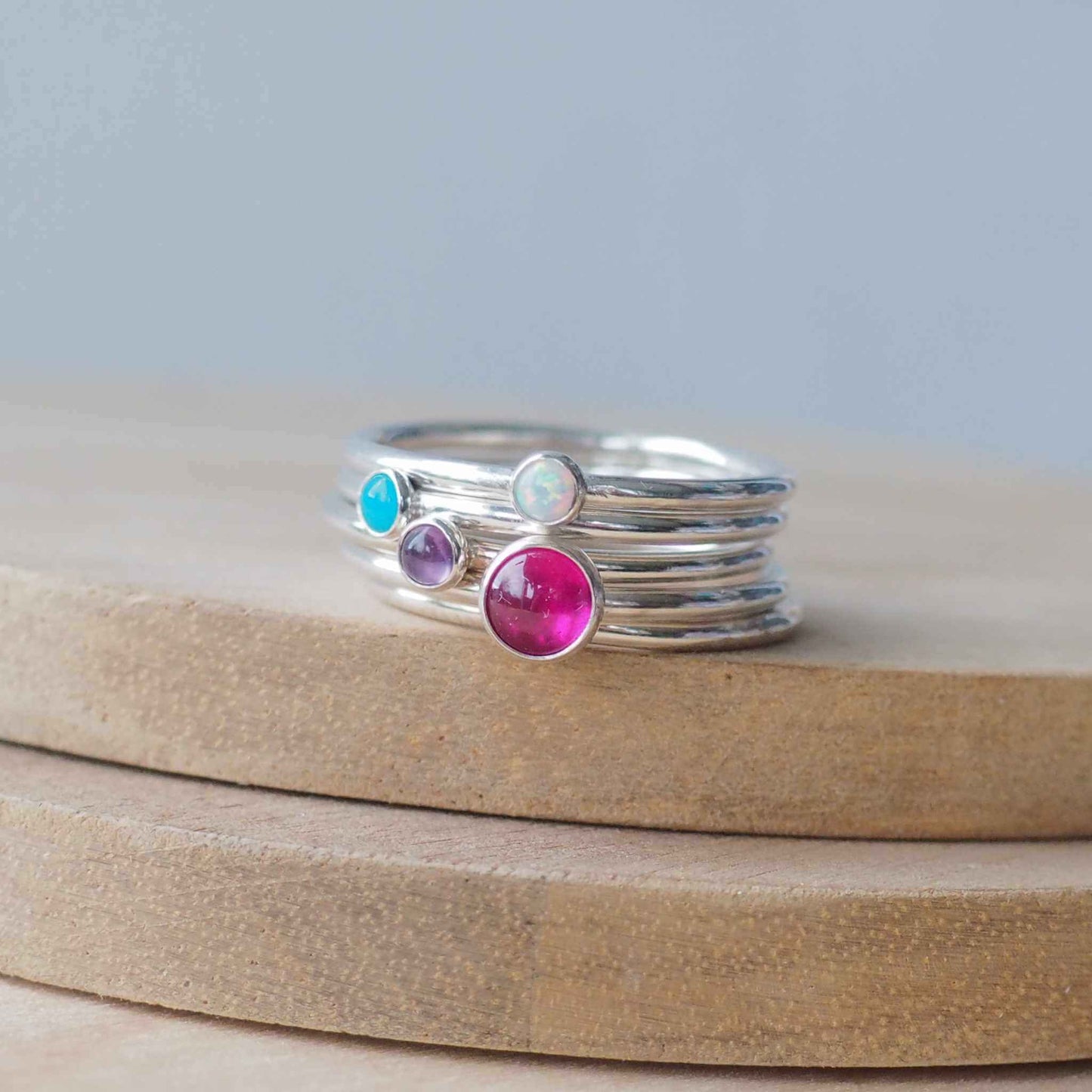 Four Birthstone ring set with July Main Birthstone, Lab Ruby, and any other three birthstones. The stones in the image are a hot pink 5mm lab ruby,and 3mm peridot, Turquoise, and Lab Ruby . Four separate rings all in Sterling Silver, and handmade in Edinburgh by Maram Jewellery