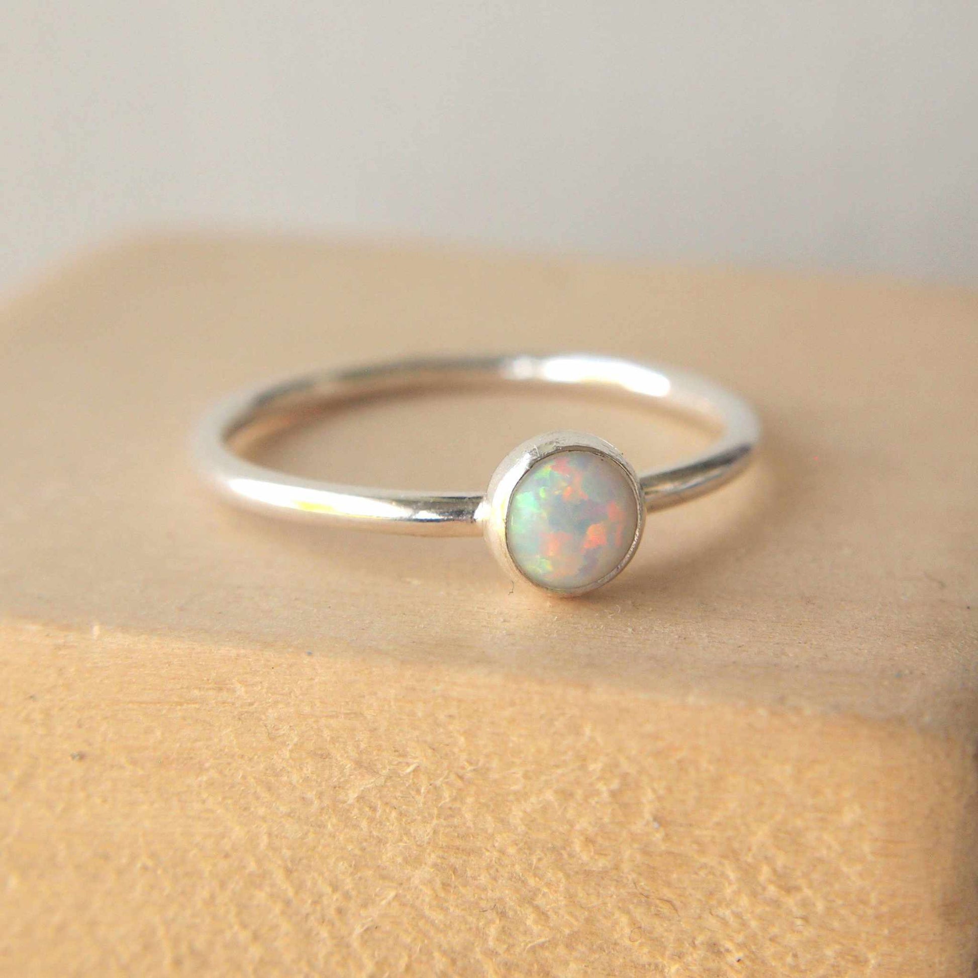 Simple style Lab Opal and Sterling Silver single Solitaire Ring with Lab Opal. Opal is Birthstone for October. THe round 5mm gem is a blue opal with lots of iridescence. Handmade by Maram Jewellery in Scotland