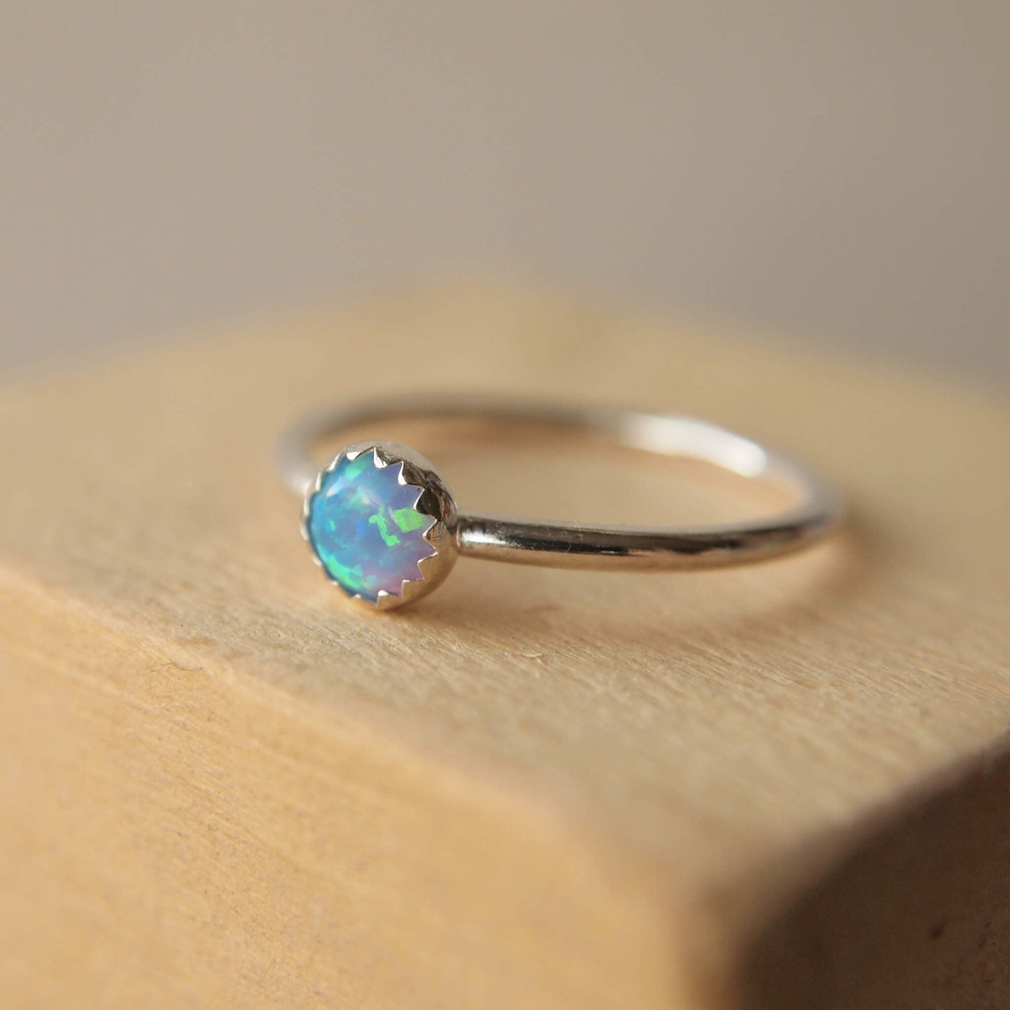 Simple style Lab Opal and Sterling Silver single Solitaire Ring with Lab Opal. Opal is Birthstone for October. THe round 5mm gem is a blue opal with lots of iridescence. Handmade by Maram Jewellery in Scotland