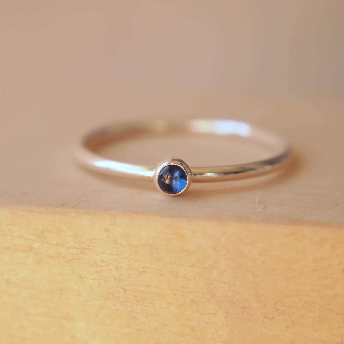 Simple Sapphire gemstone ring in sterling silver with a modern round band with a 3mm sized round Blue Sapphire Cabochon. Handmade in Edinburgh by Maram Jewellery