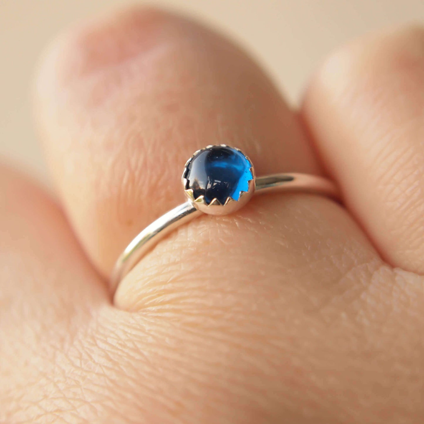 Simple styled silver and blue gemstone ring with a lab sapphire round stone on a silver band. The ring is made from a 5mm round cabochon in bright blue. Handmade to your choice of ring size by maram jewellery in Scotland