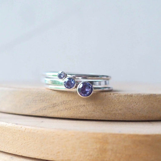 three tanzanite rings with 2mm, 3mm and 4mm round tanzanite cubic zirconia on plain silver bands. customise to your choice of gem size and band style . Handmade in Scotland by maram jewellery