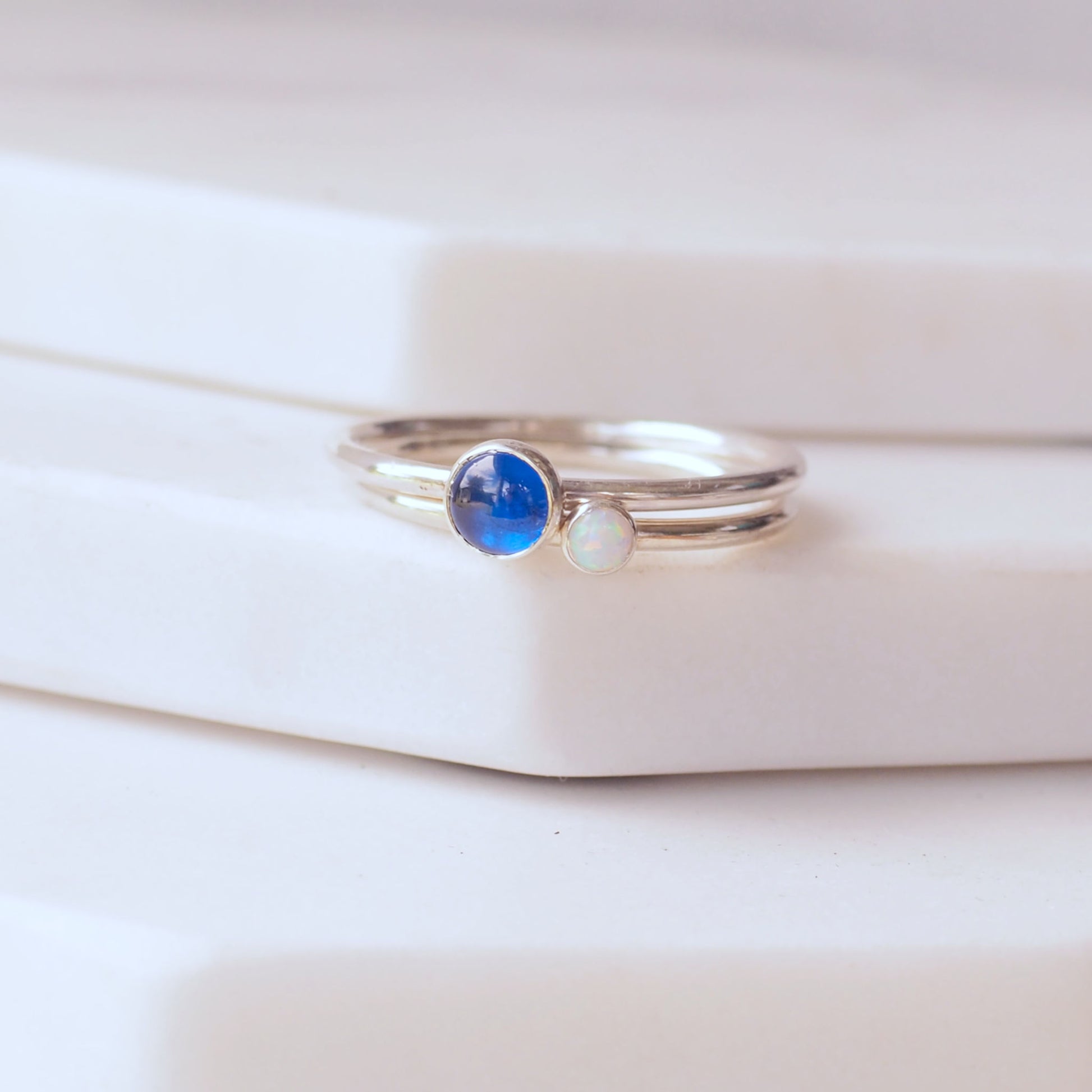 Two ring set with A September and October birthstone - a bright blue lab sapphire and a bright white Lab Opal . Handmade in Scotland by maram jewellery