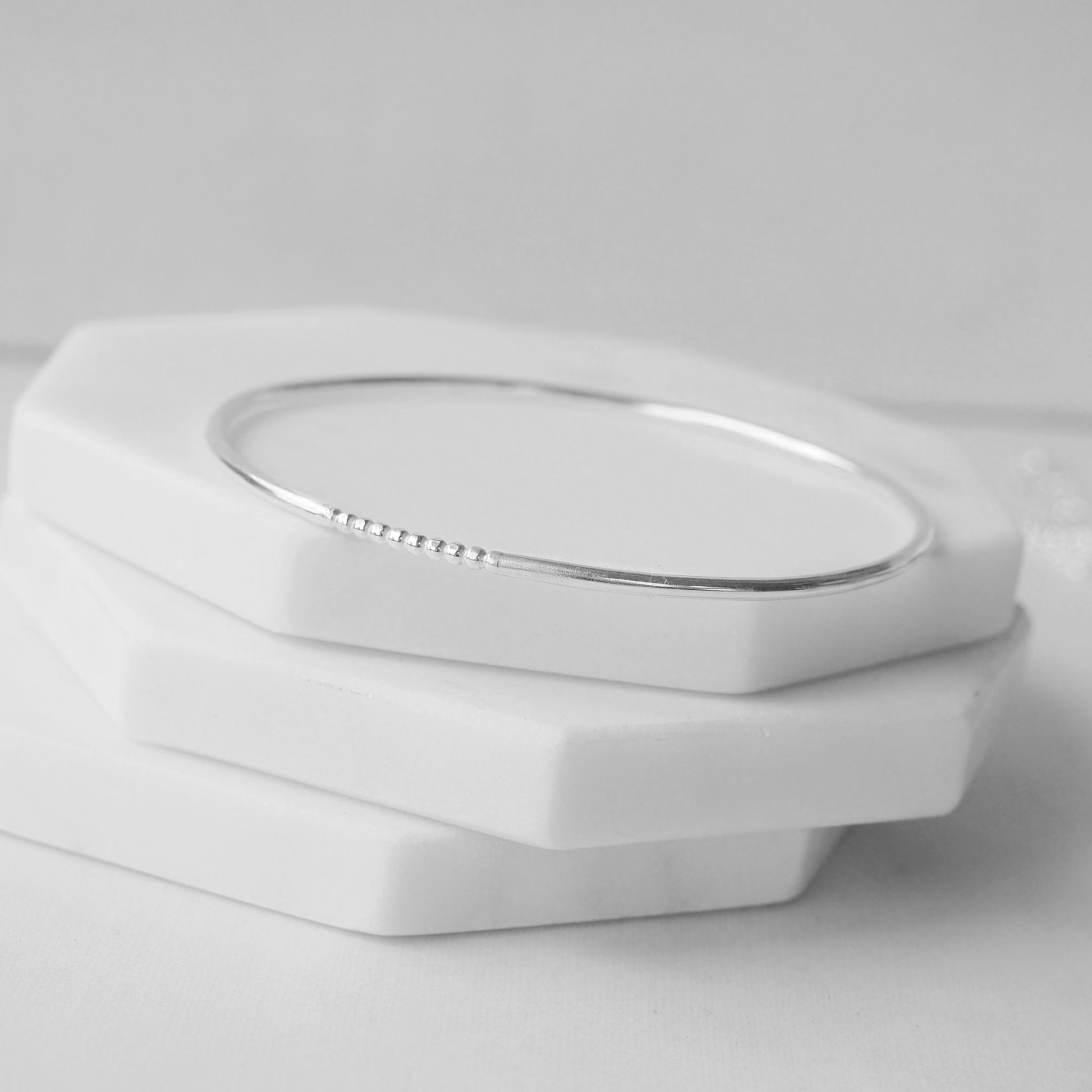 Silver bangle made by maram jewellery in Scotland UK. Made in a round halo profile with a fixed beaded section. THese bangles are made with leftover sections on silver so are eco friendly. Made in Scotland UK