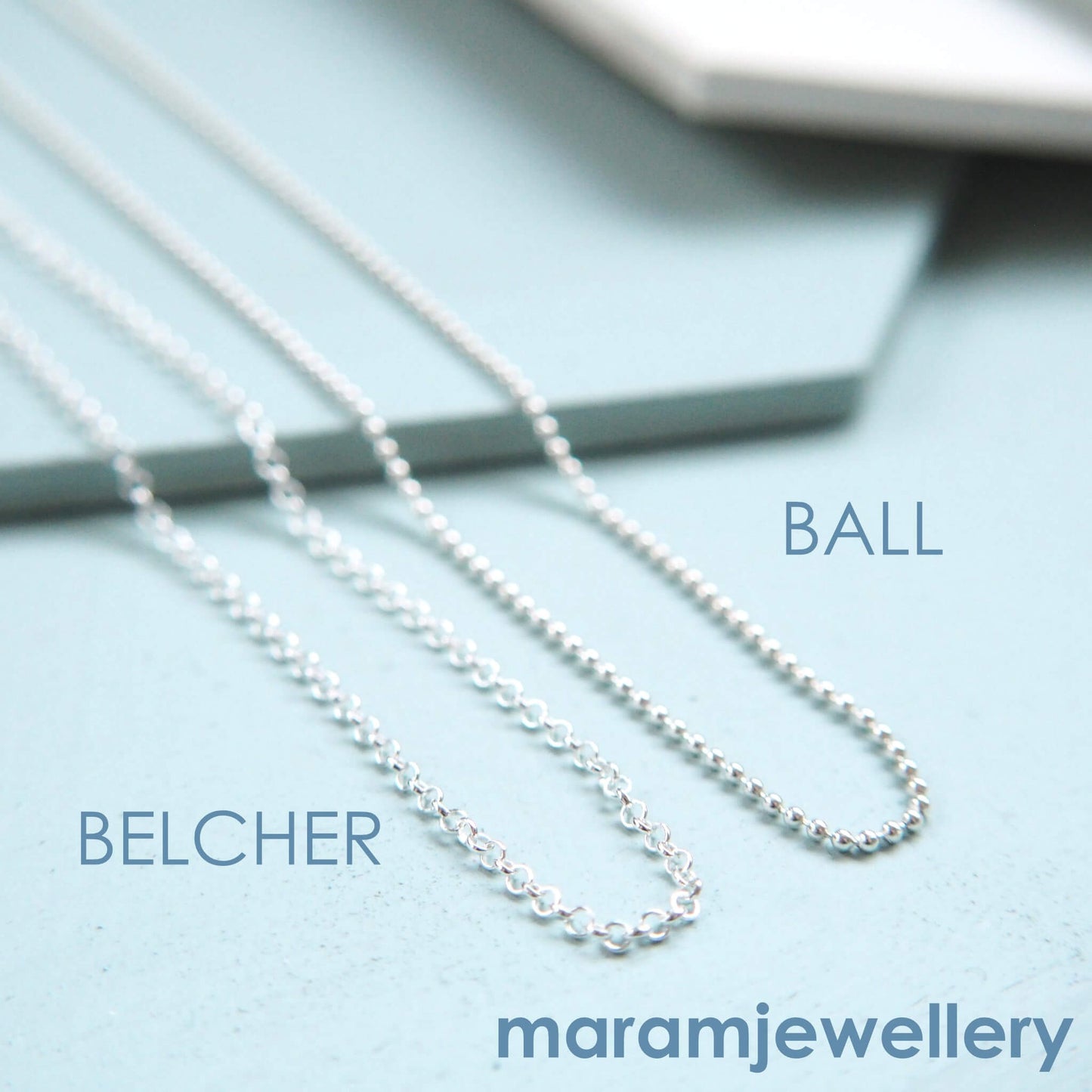 Chains available for maram jewellery pendants pictured on a duck blue background. THe chains are a simple ball chain and a narrow belcher/rolo chain. Available on necklaces made by maram jewellery in Scotland UK