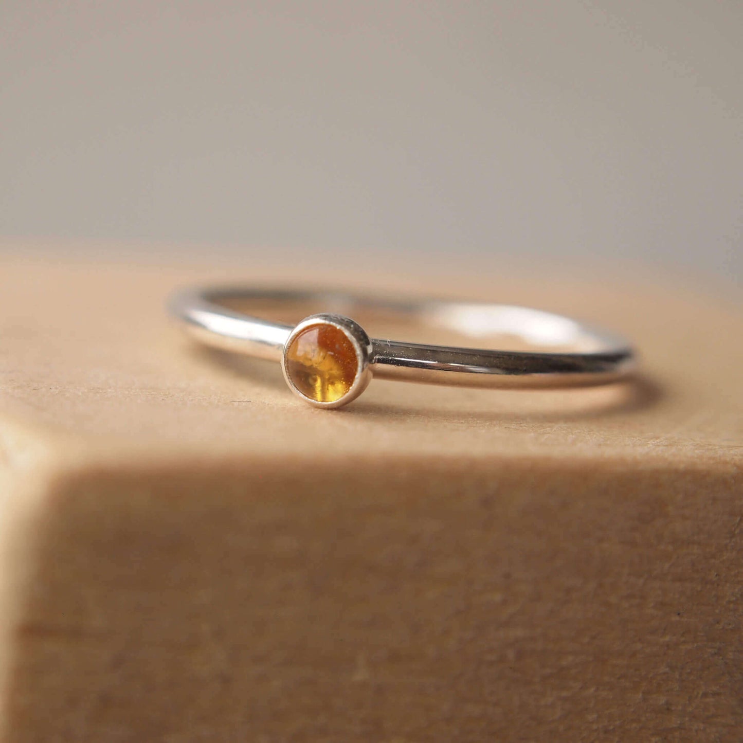 Citrine and Sterling Silver Ring made from a small 3mm round warm yellow citrine gemstone set simply onto a modern band of fully round wire. Handmade to your ring size by maram jewellery in Scotland