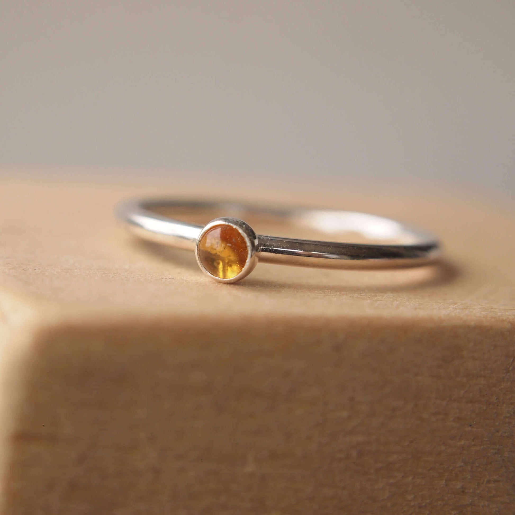 Citrine and Sterling Silver Ring made from a small 3mm round warm yellow citrine gemstone set simply onto a modern band of fully round wire. Handmade to your ring size by maram jewellery in Scotland
