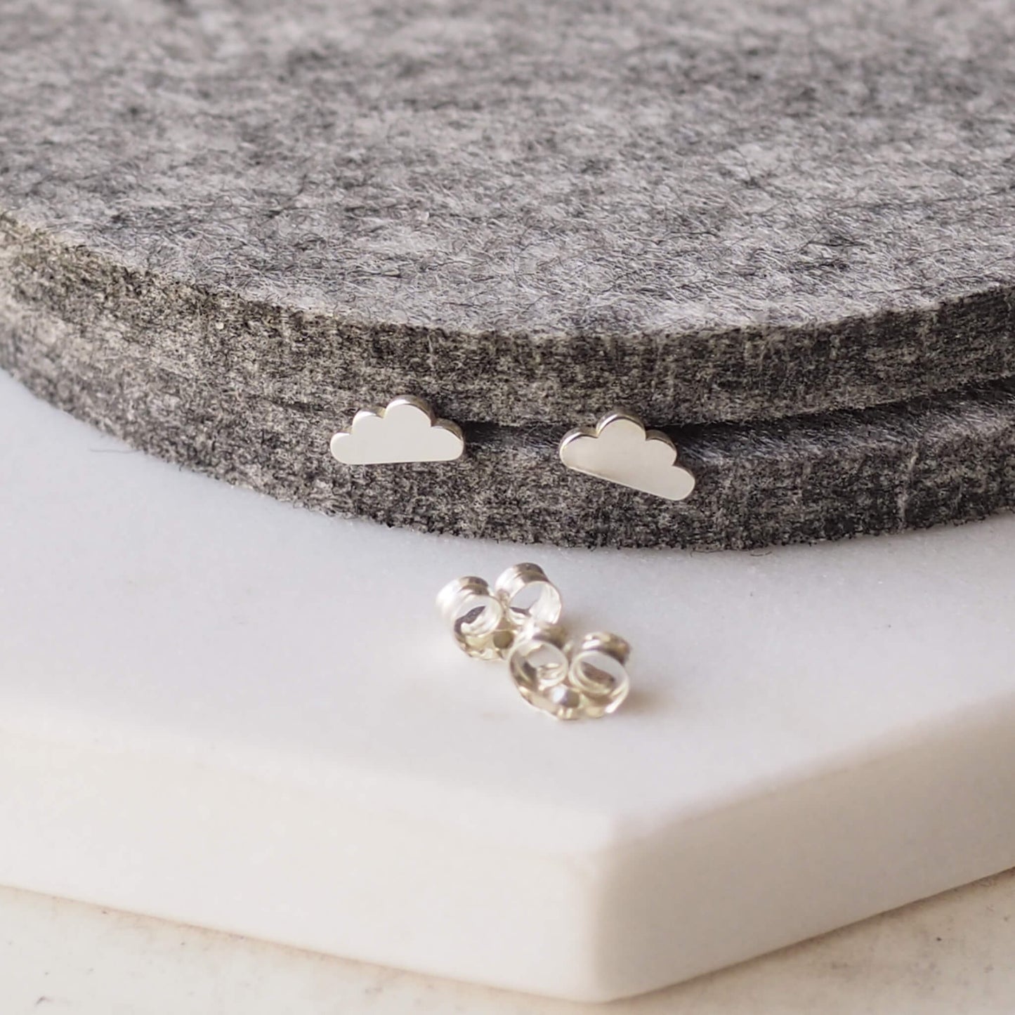 Sterling silver dinky little cloud earrings pictured with butterfly back. available at maram jewellery, a small indie jeweller in Edinburgh UK