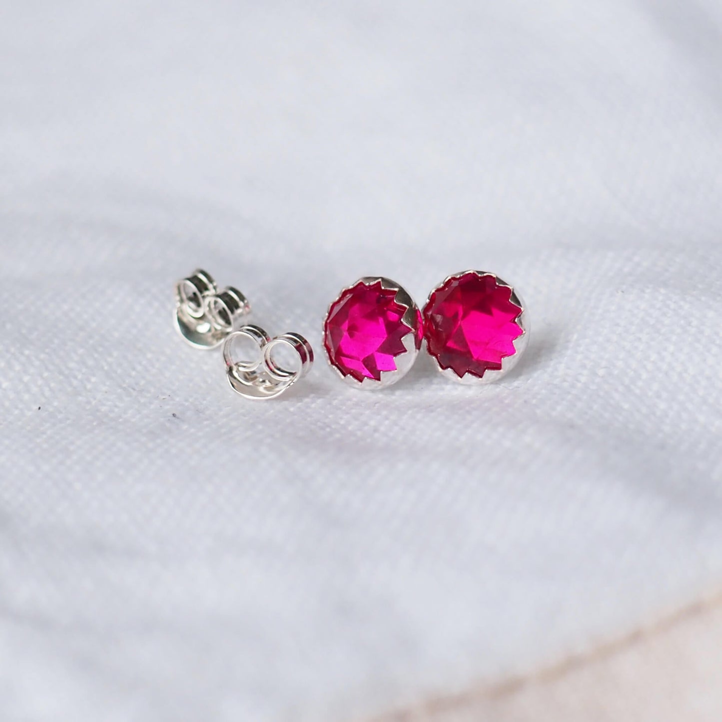 July Birthstone earrings featuring hot pink Gemstone stud earrings with a bright lab ruby artificial gemstone, round and faceted 6m in size. Set onto Sterling Silver settings. Birthstone for July Handmade in Scotland UK by maram jewellery