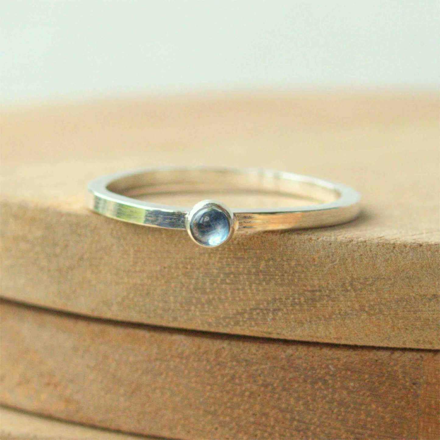Small gemstone ring in sterling silver with a modern square band with a 3mm sized round light blue Aquamarine. Handmade in Edinburgh by Maram Jewellery