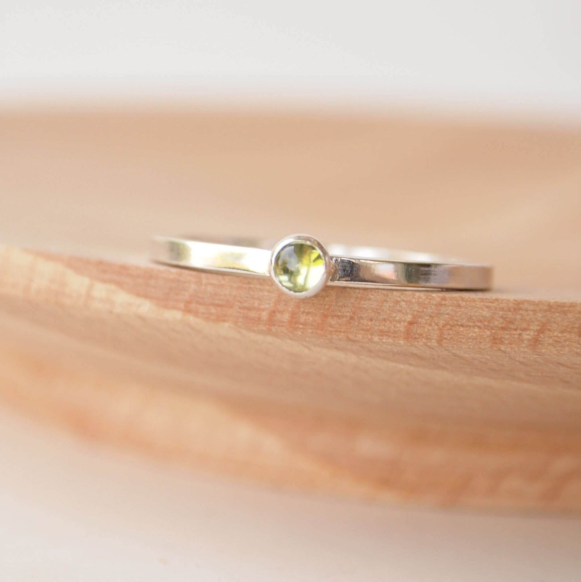 Small Peridot gemstone ring in sterling silver with a modern square band with a 3mm sized round moss green Peridot. Handmade in Edinburgh by Maram Jewellery