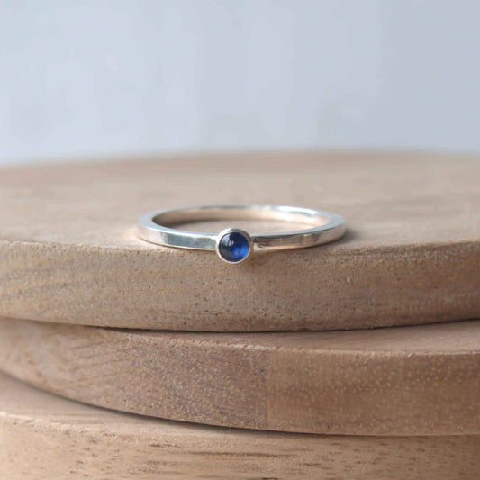 Simple Sapphire gemstone ring in sterling silver with a modern square band with a 3mm sized round Blue Sapphire Cabochon. Handmade in Edinburgh by Maram Jewellery