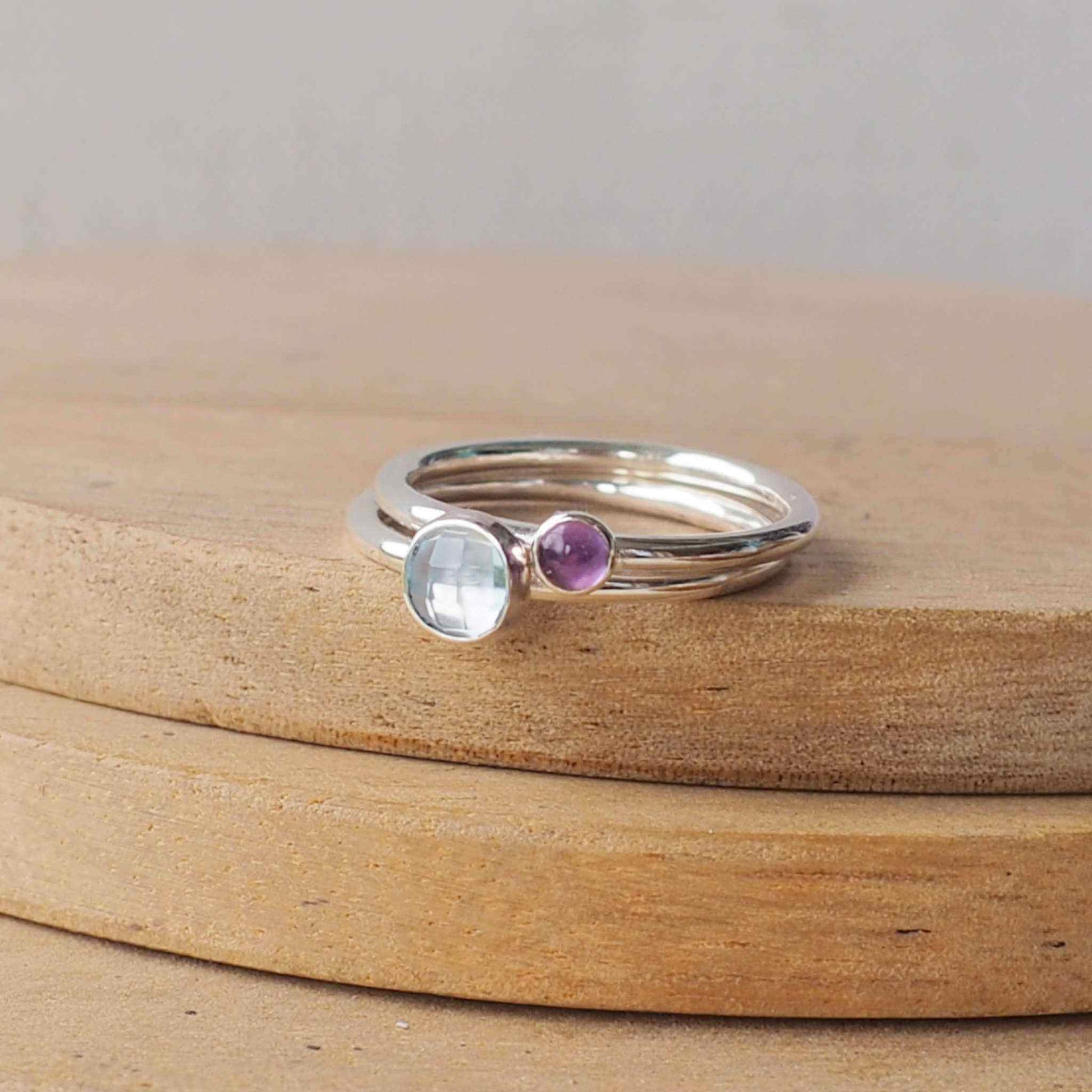 Two Birthstone Ring set with Blue Topaz and Amethyst to mark March and February Birthdays. The two rings are made with Sterling Silver and a 5mm blue round cabochon, with a further ring with 3mm round gem in a purple amethyst . Handmade in Scotland by maram jewellery