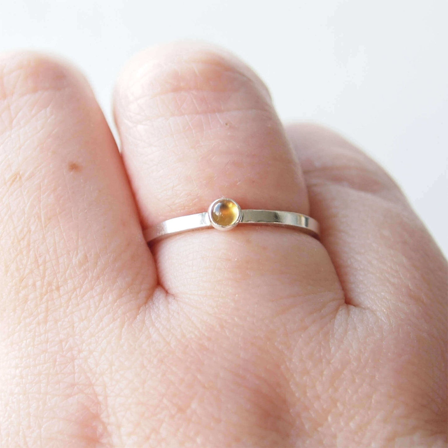 Citrine and Sterling Silver Ring made from a small 3mm round warm yellow citrine gemstone set simply onto a modern band of Square wire. Handmade to your ring size by maram jewellery in Scotland
