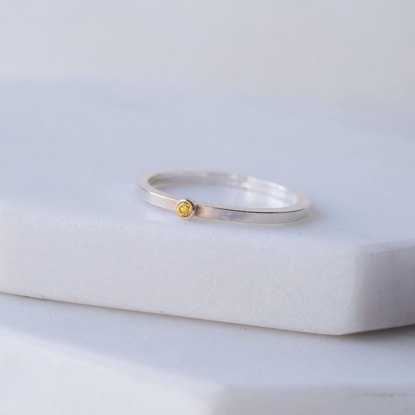 Citrine facet cut ring with a tiny gemstone set onto a square wire band in Sterling Silver. Handmade by maram jewellery in Scotland UK