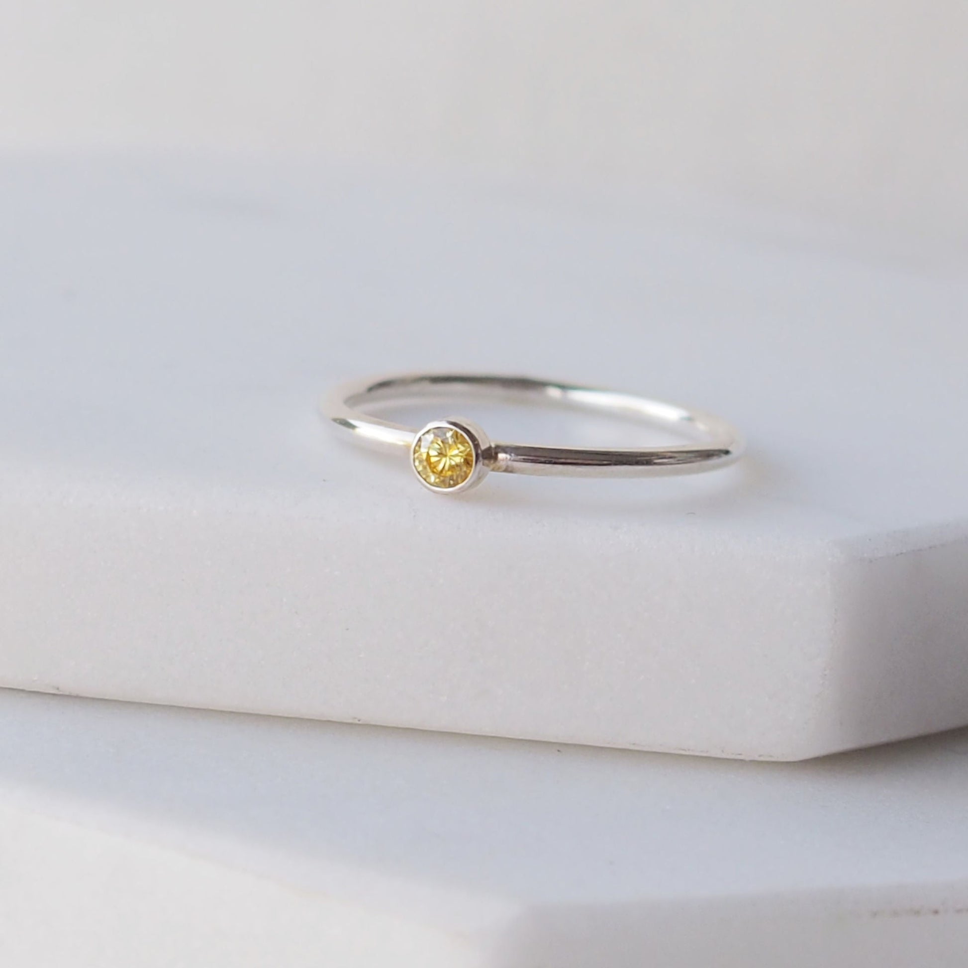 Citrine facet cut ring with a small gemstone set onto a round wire band in Sterling Silver. Handmade by maram jewellery in Scotland UK