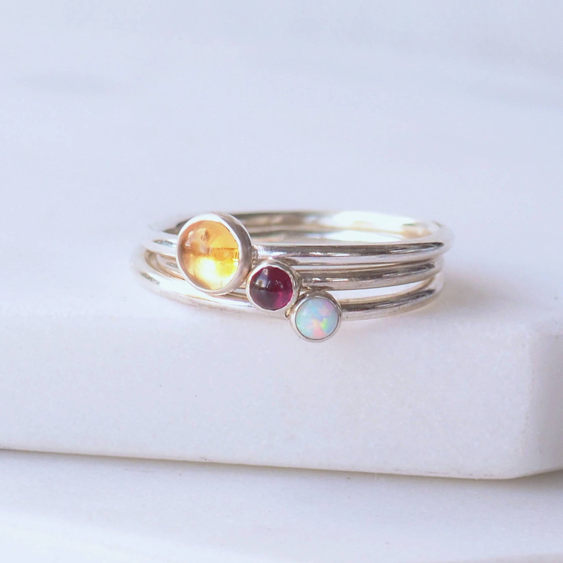 Three Silver birthstone rings with a large round Yellow Citrine for November with two additional birthstone rings of your choice, picture shows deep red garnet and white lab opal. Handmade by maram jewellery in Scotland UK