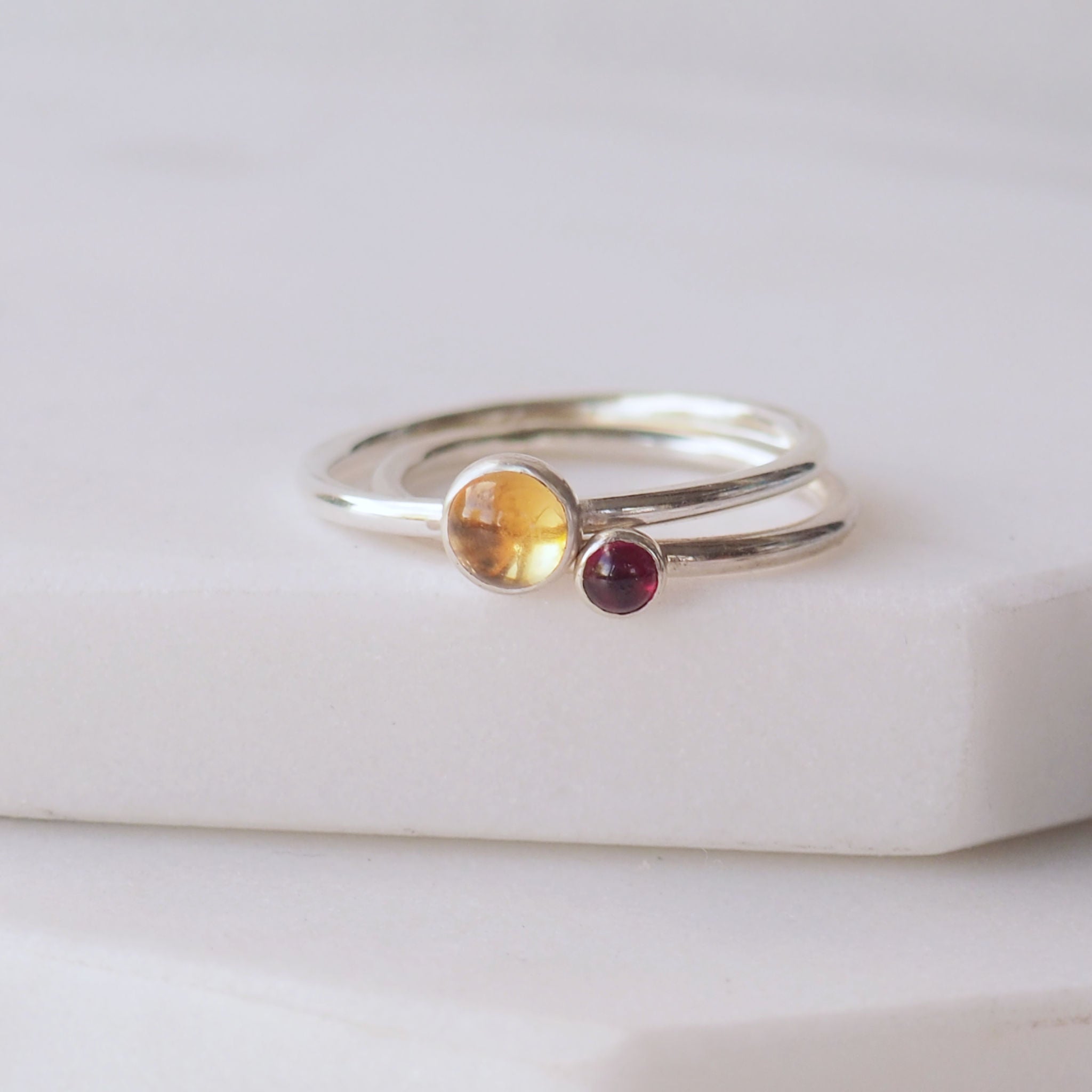 Two silver rings with Yellow Citrine and Garnet round gemstones. Birthstones for November and January. Handmade to your ring size by maram jewellery in Scotland , UK