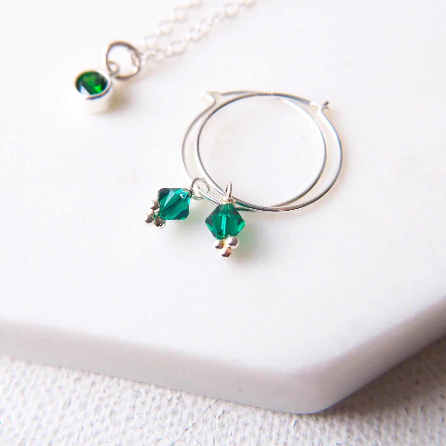 Emerald Crystal Droppers on a thin wire hoop creating simple boho hoop earrings. handmade by maram jewellery in Scotland UK
