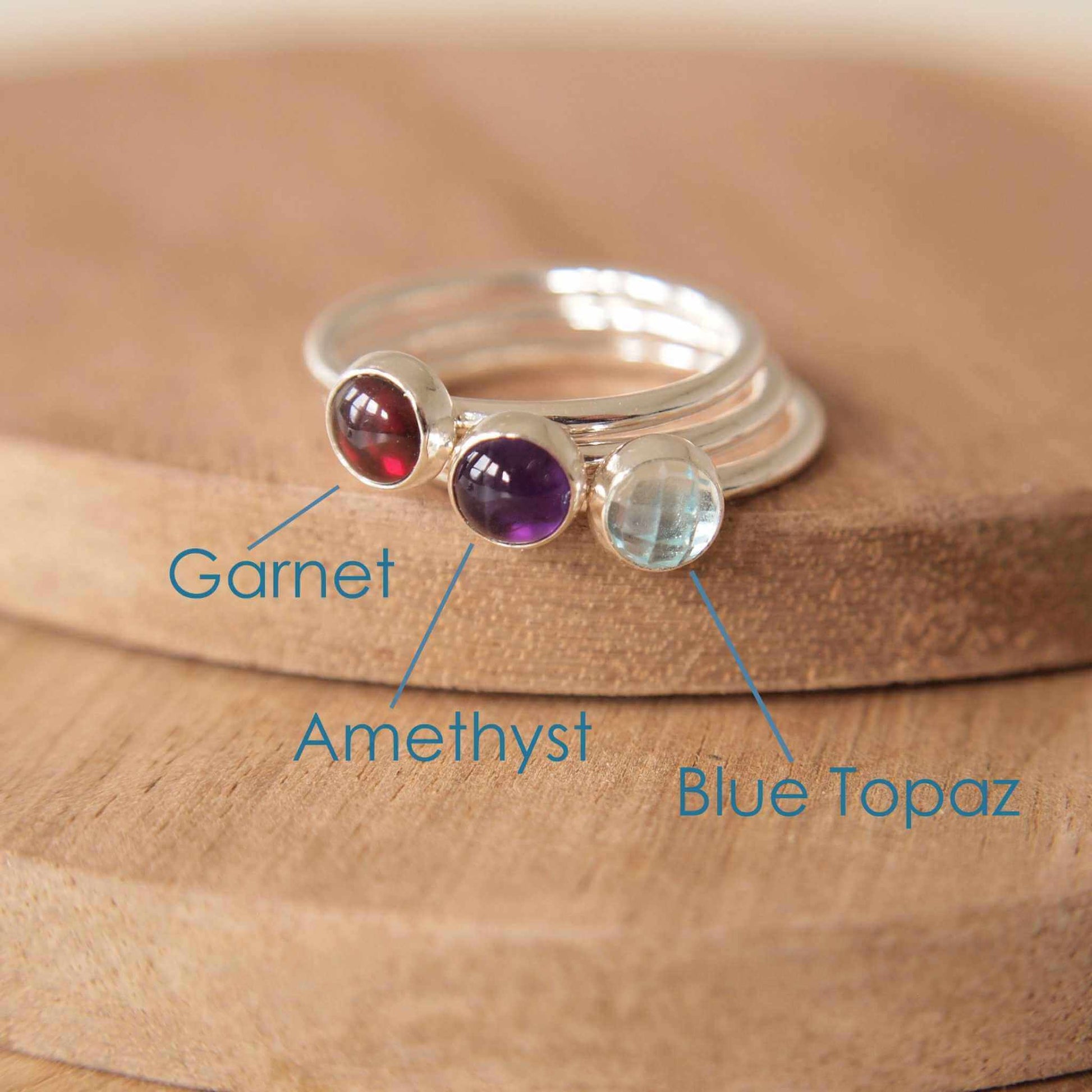 Three Silver rings, each set simply with a single gemstone in Garnet, Amethyst and Blue Topaz in a round 5mm size. Birthstones for January, February and March. Handmade by Maram Jewellery in Edinburgh