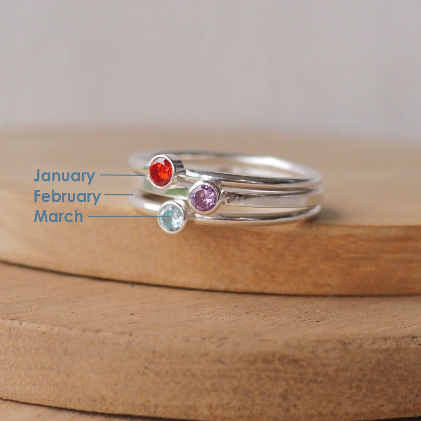 Three silver and gemstone rings with January, February and March birthstones. Silver rings with a 3mm size stone in simple style with a red, purple and aqua gemstone. Handmade in Scotland by Maram Jewellery