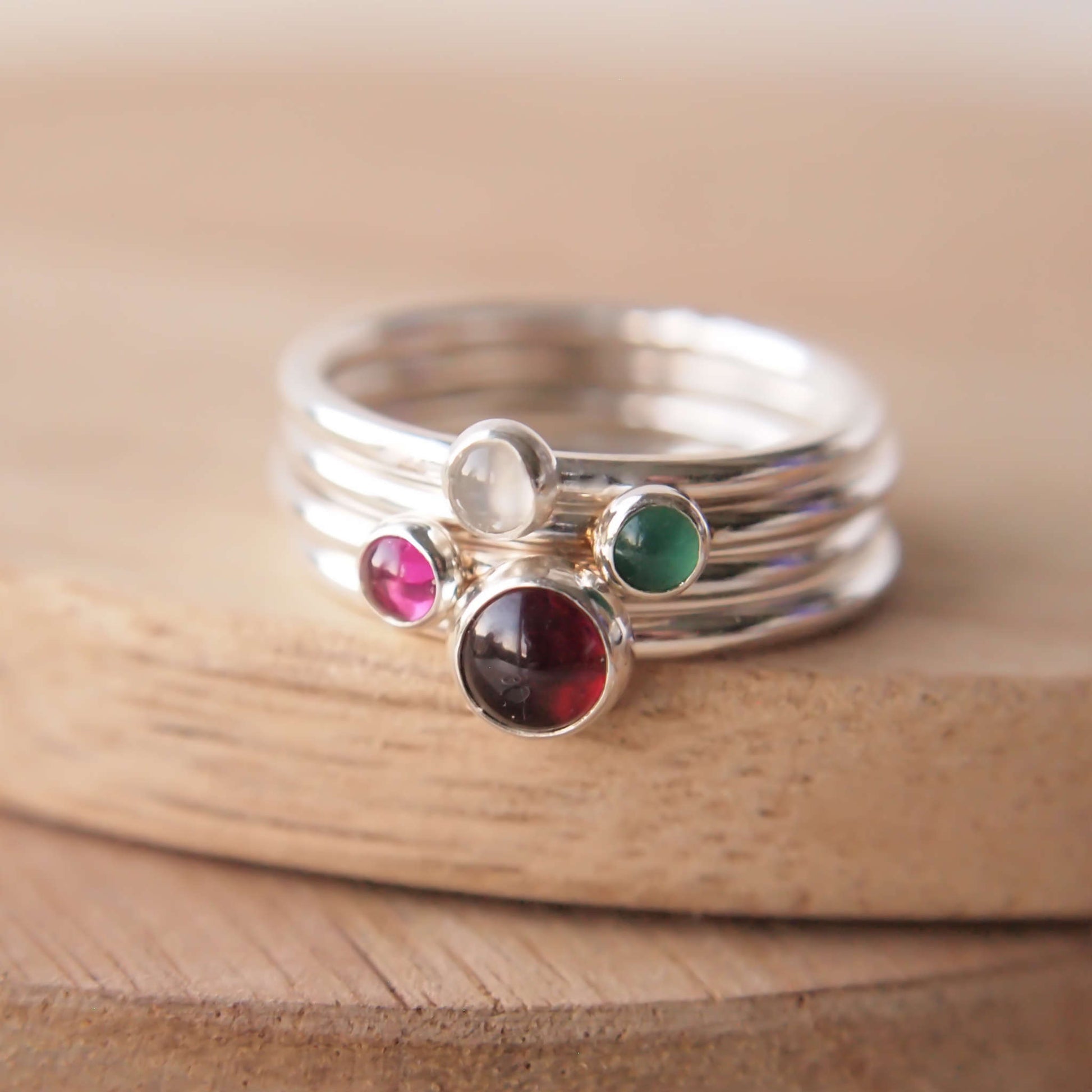 Four ring set with family birthstones and sterling Silver  with a 5mm round red garnet, green Agate, Pink Lab Ruby and a white Moonstone. Handmade by maram jewellery in Edinburgh UK 
